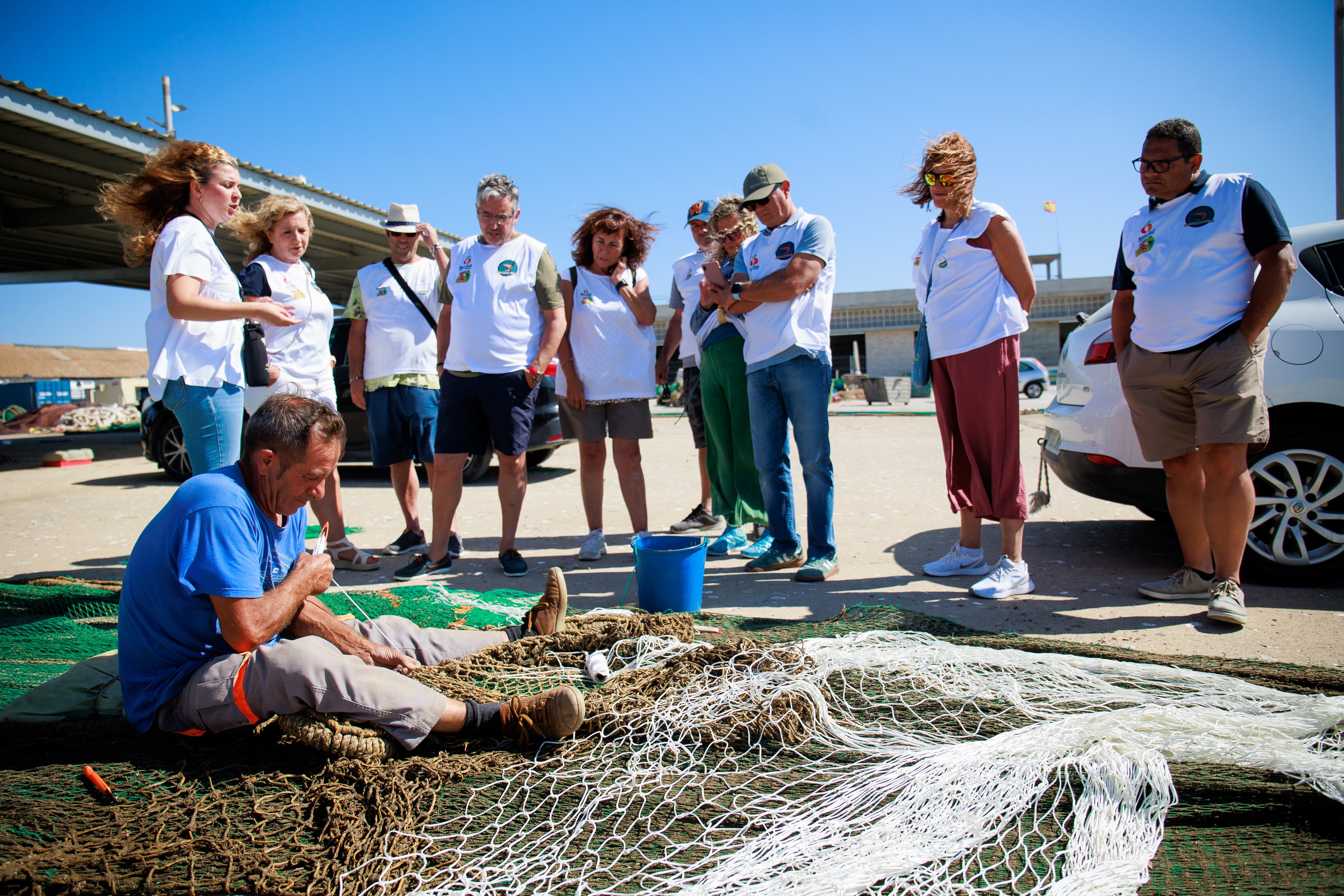 Los visitantes observan el trabajo de un redero.