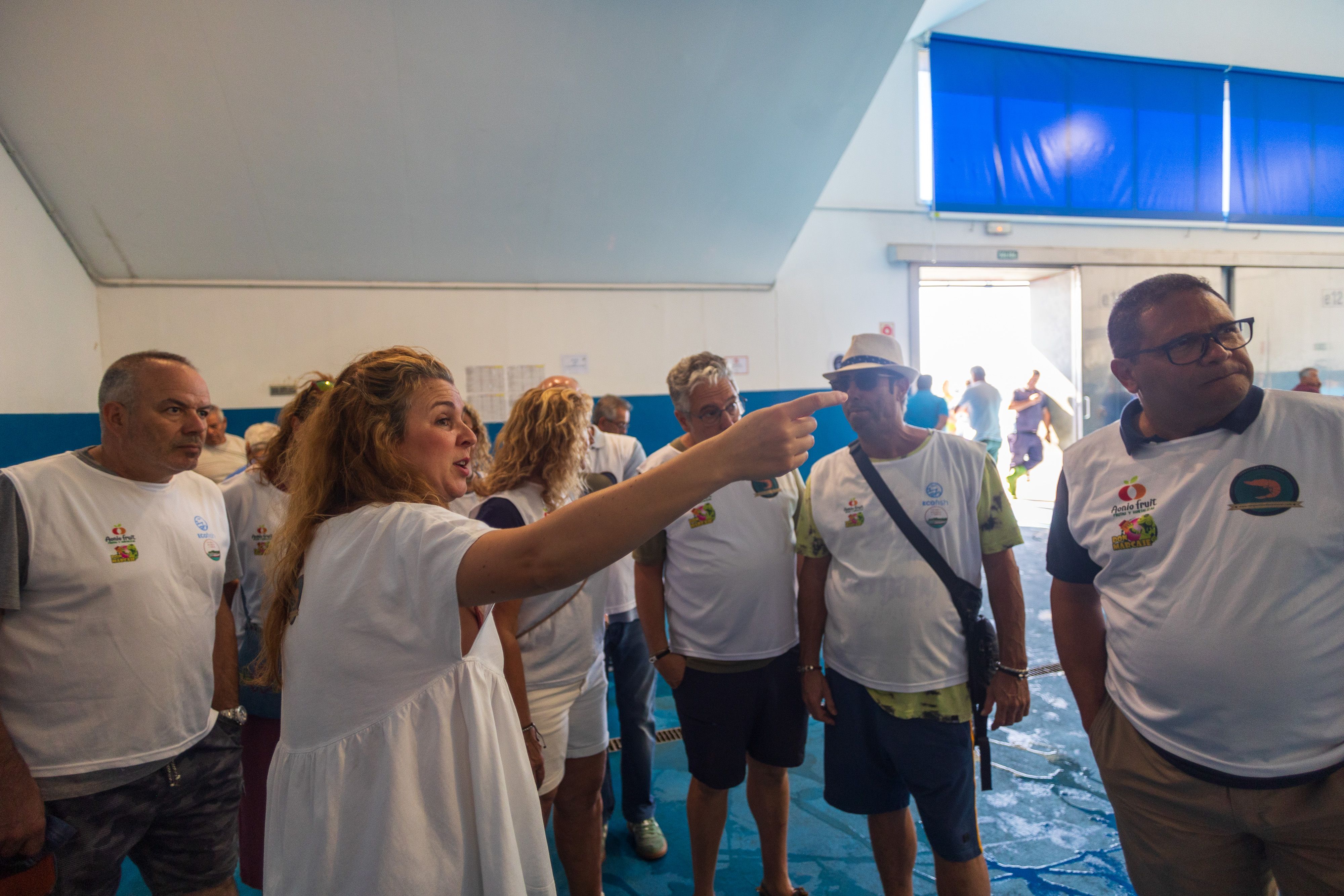 Tatiana conduce al grupo hacia la zona de subastas.