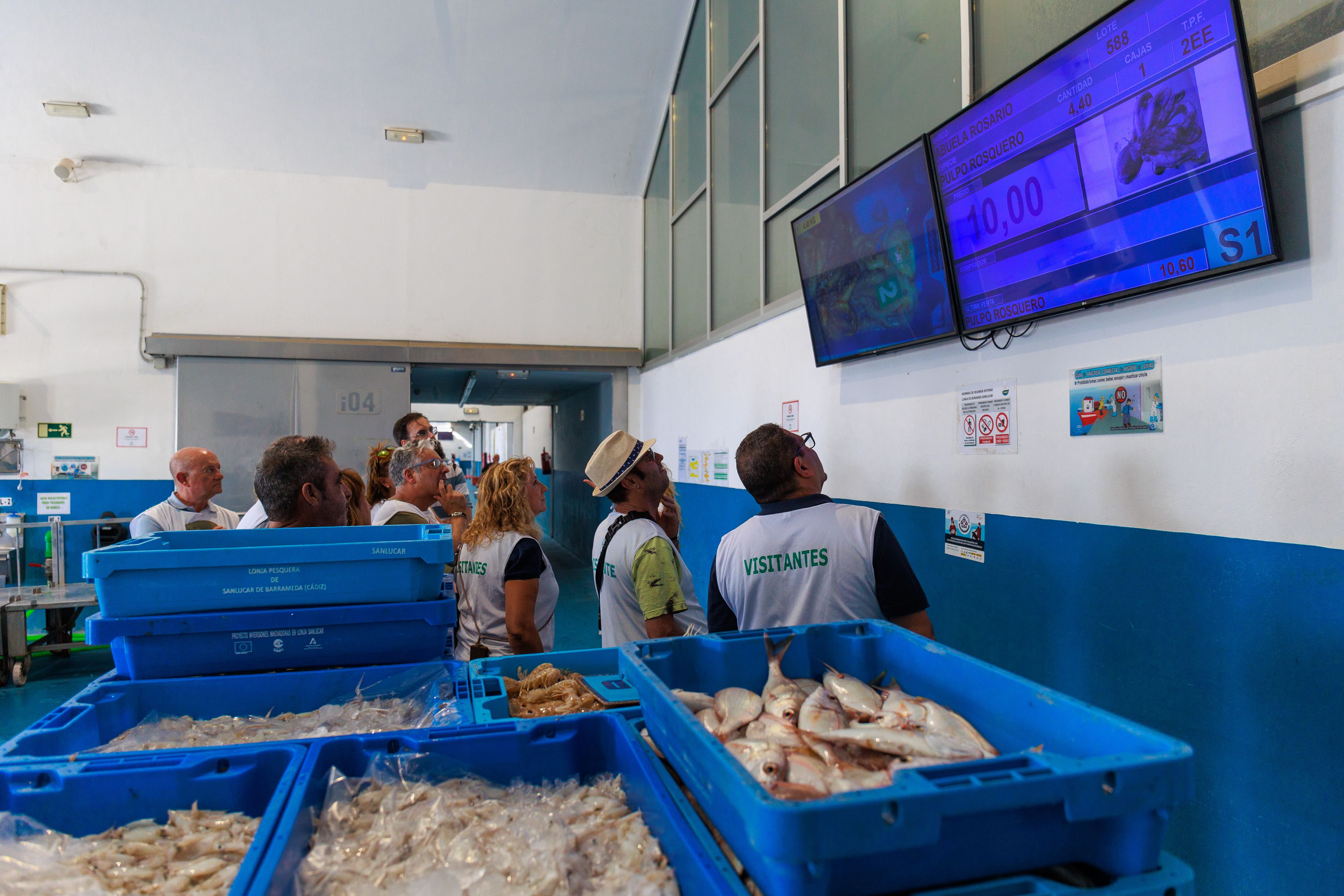 Los turistas observan las pantallas.