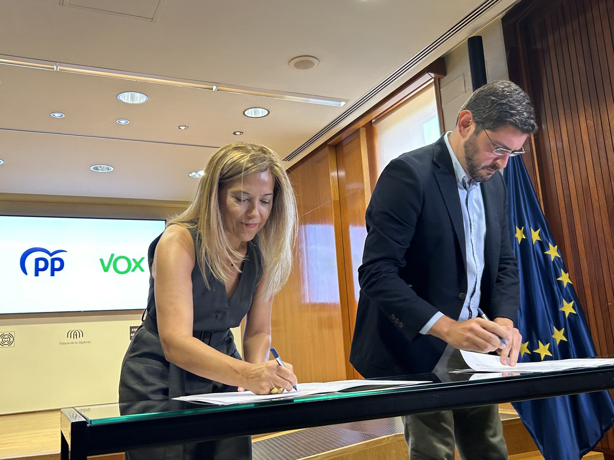 Los portavoces parlamentarios de PP y Vox firmando el acuerdo de gobierno.