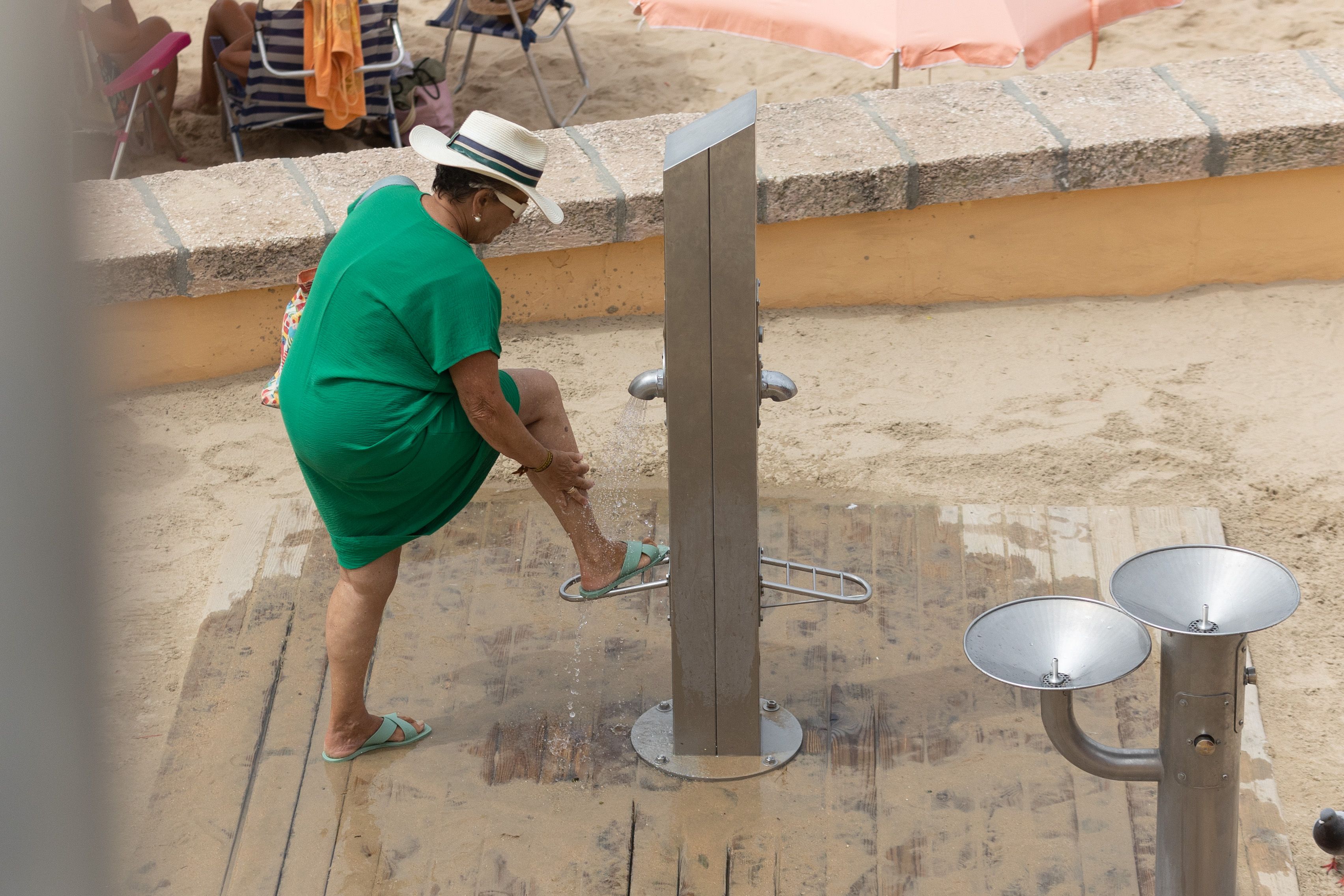 Una usuaria utiliza el lavapiés de la playa de La Caleta este mes de agosto.