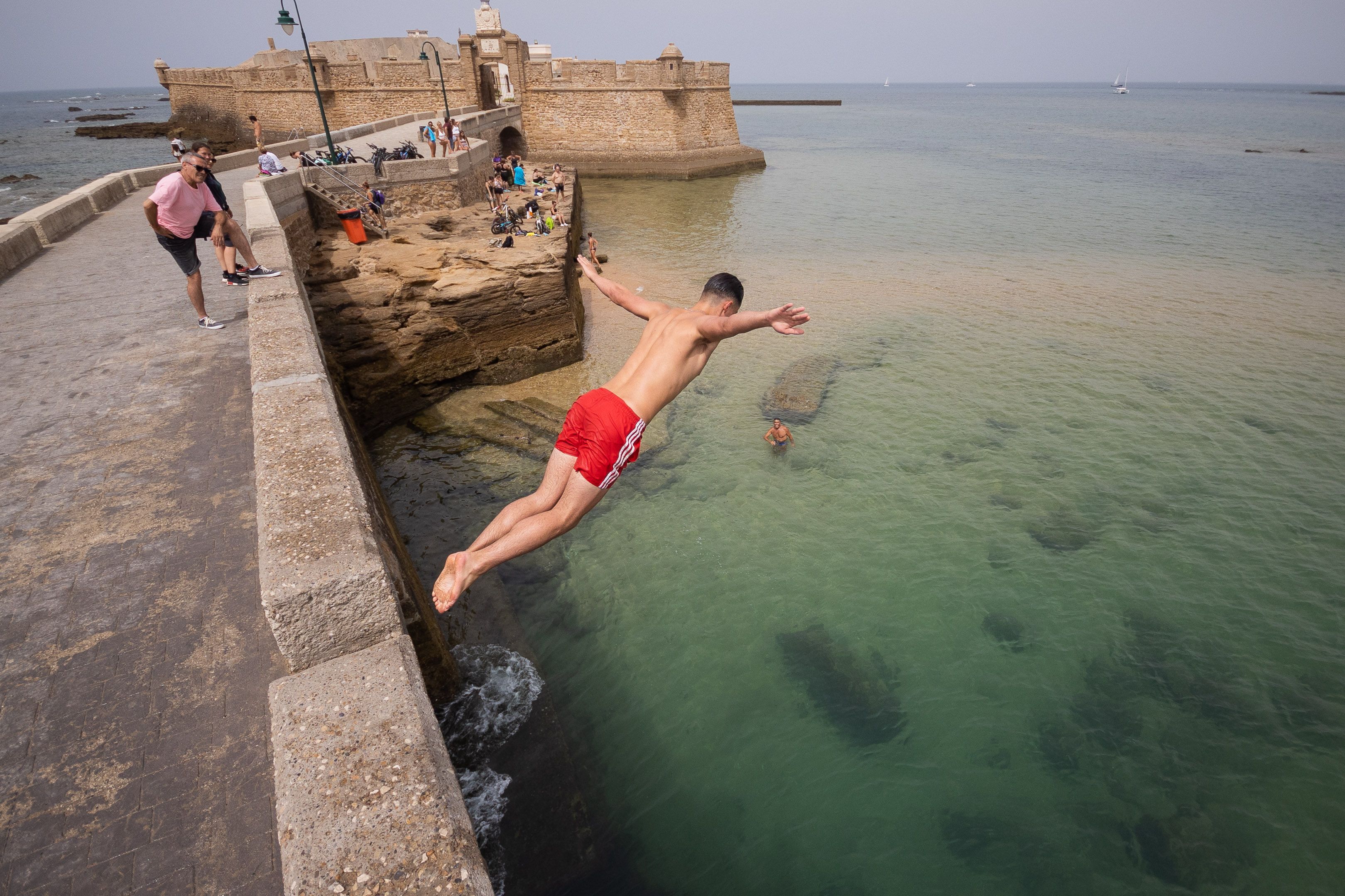 Tarajes. Un bañista se lanza al agua en el Puente Canal, en Cádiz.