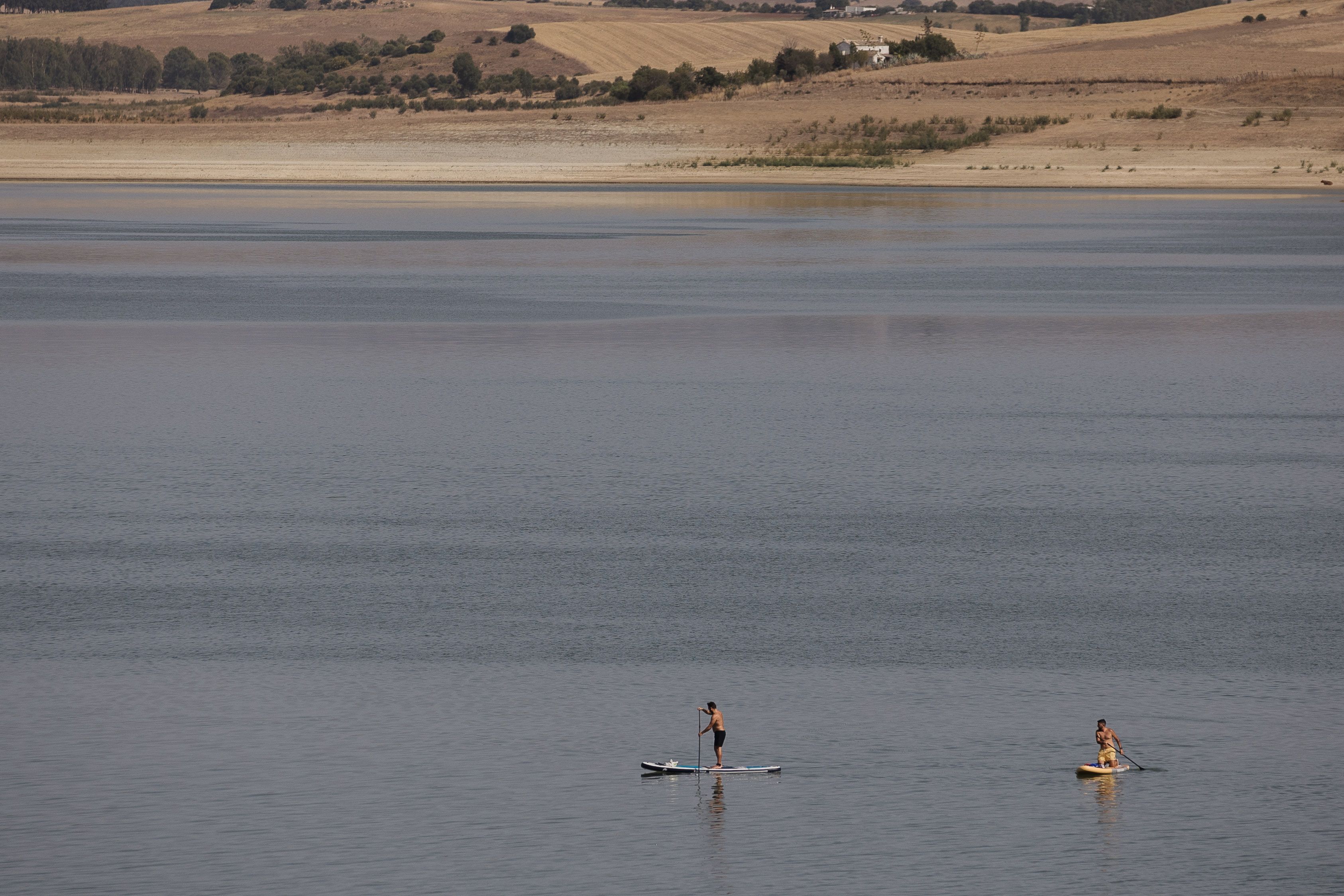 Personas practicando deporte en un pantano, en plena sequía, con falta de agua.