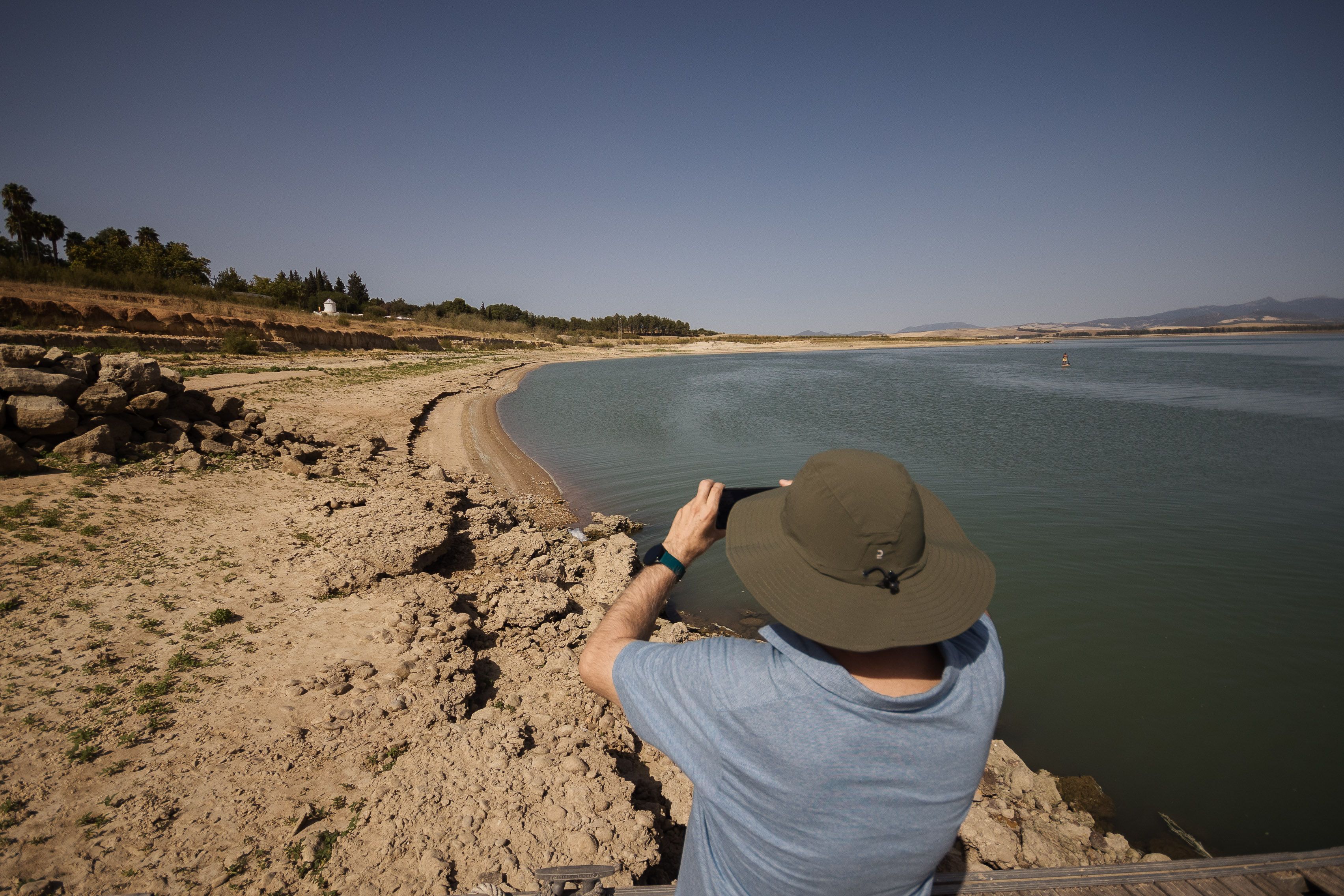 Una persona toma fotos de la falta de agua en el embalse de Bornos, en la provincia de Cádiz.