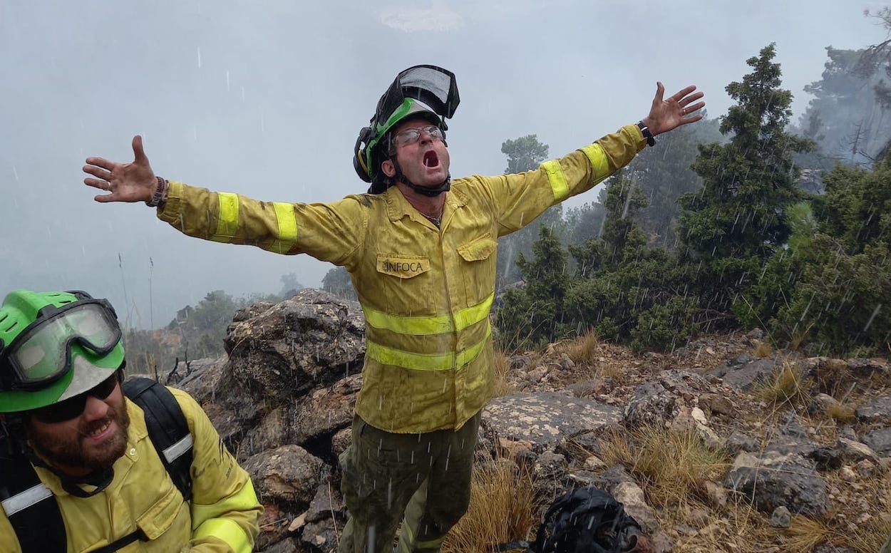 Lucha contra los incendios forestales: ocho investigados-detenidos por la Policía Adscrita. En la imagen, un bombero recibiendo con alivio el agua que le cae. Lucha contra los incendios forestales: ocho investigados-detenidos por la Policía Adscrita. En la imagen, un bombero recibiendo con alivio el agua que le cae.