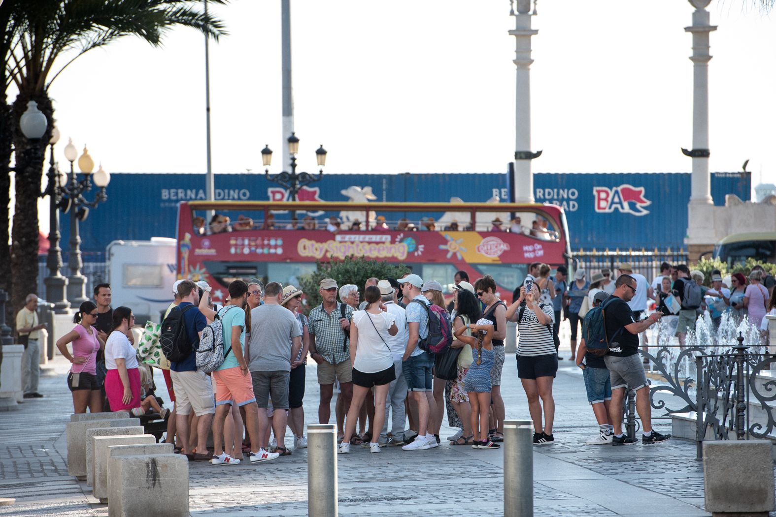 Un grupo de cruceristas, ante un autobús turístico en el centro de Cádiz en verano de 2023.