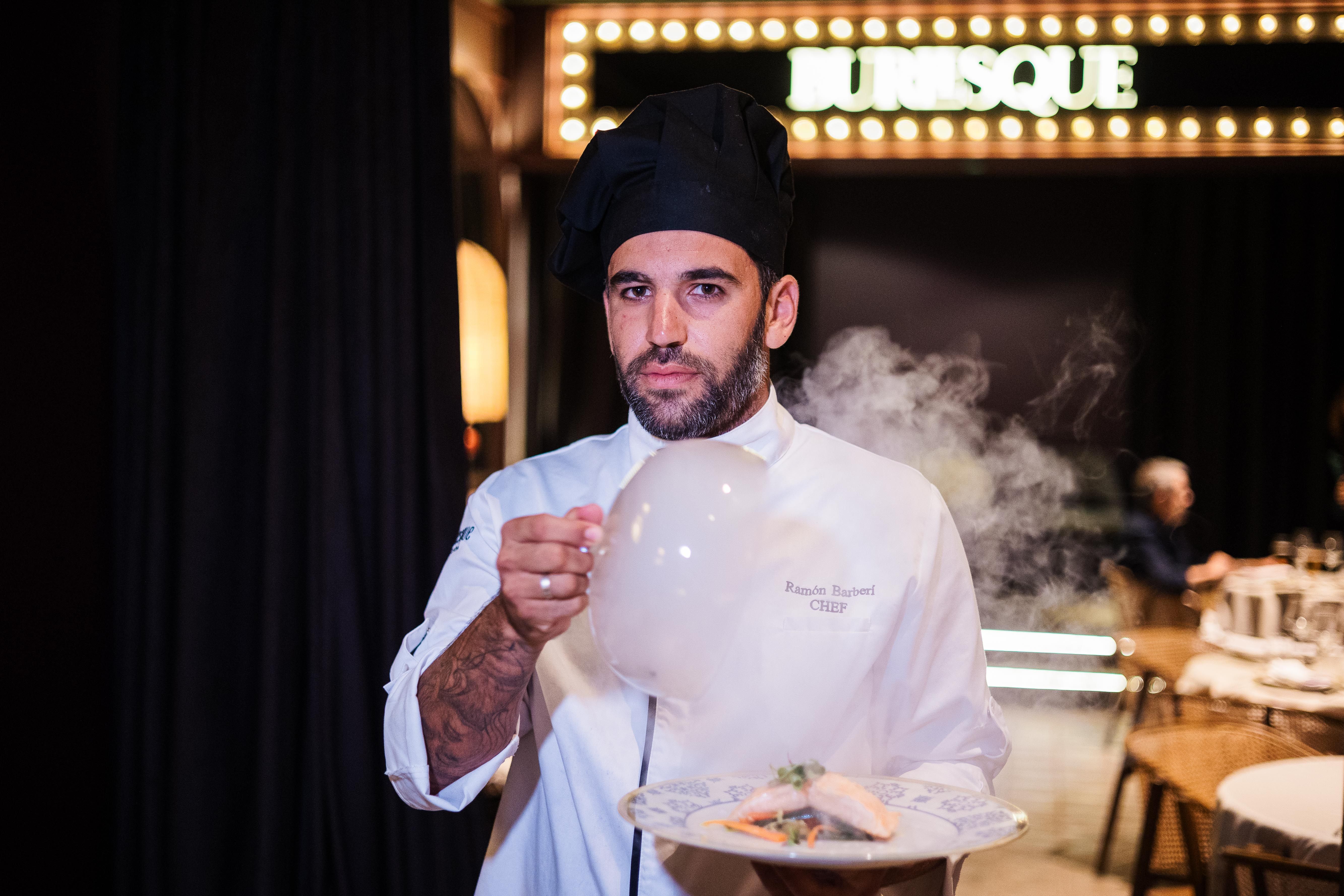 Ramón Barberi, chef ejecutivo del grupo Burlesque, muestra uno de los platos ante uno de los salones y el escenario.