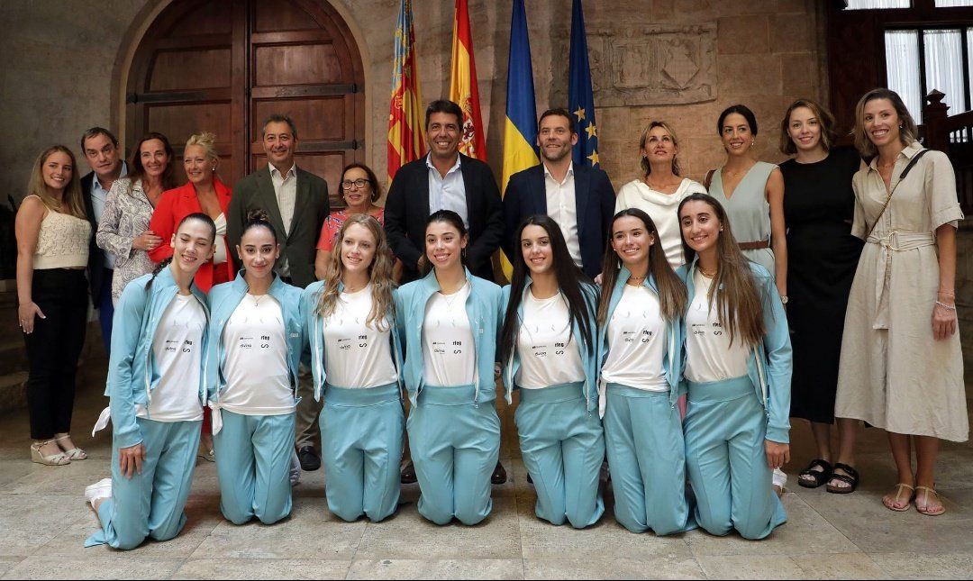 La foto de la discordia, con las campeonas de gimnasia rítimca arrodilladas y los políticos detrás.