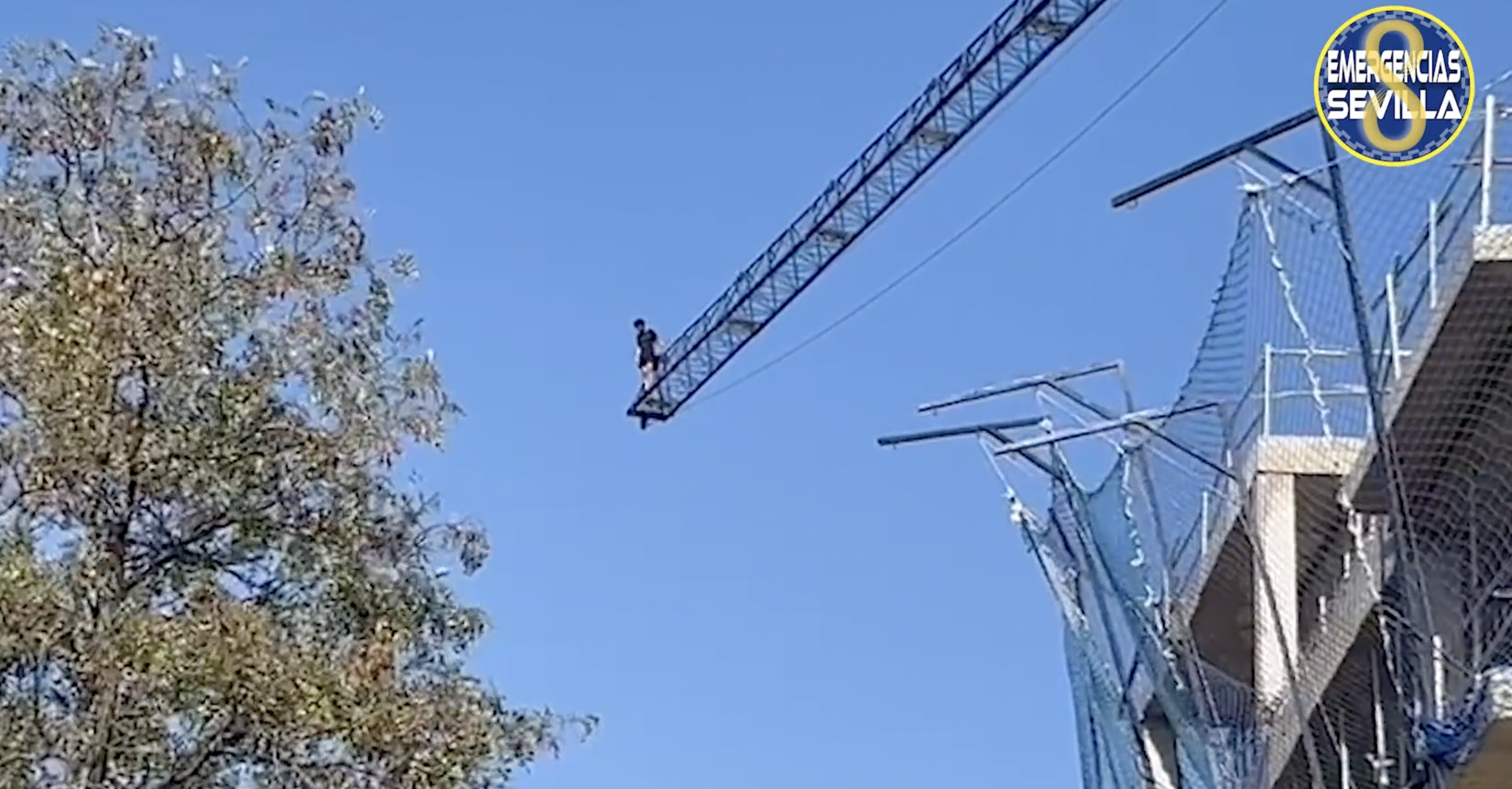 Una persona subida a una grúa de construcción en Sevilla. 