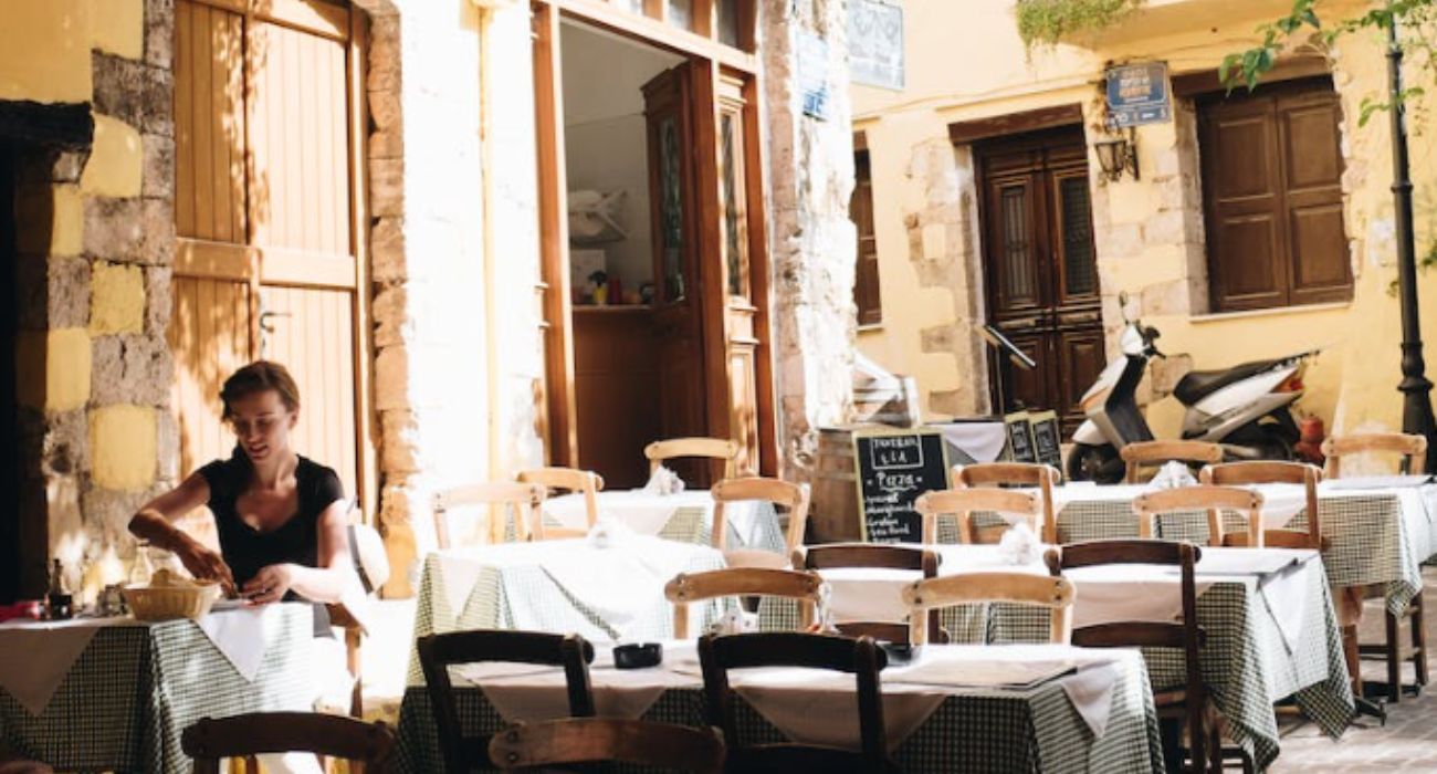 Una mujer, en la terraza de un bar. El sector servicios vuelve a ser el sector que lidera la caída del paro en Andalucía.