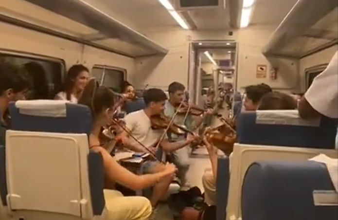 Jóvenes tocando su violín en un viaje de tren. ALBA GARCÍA Jóvenes tocando su violín en un viaje de tren. ALBA GARCÍA