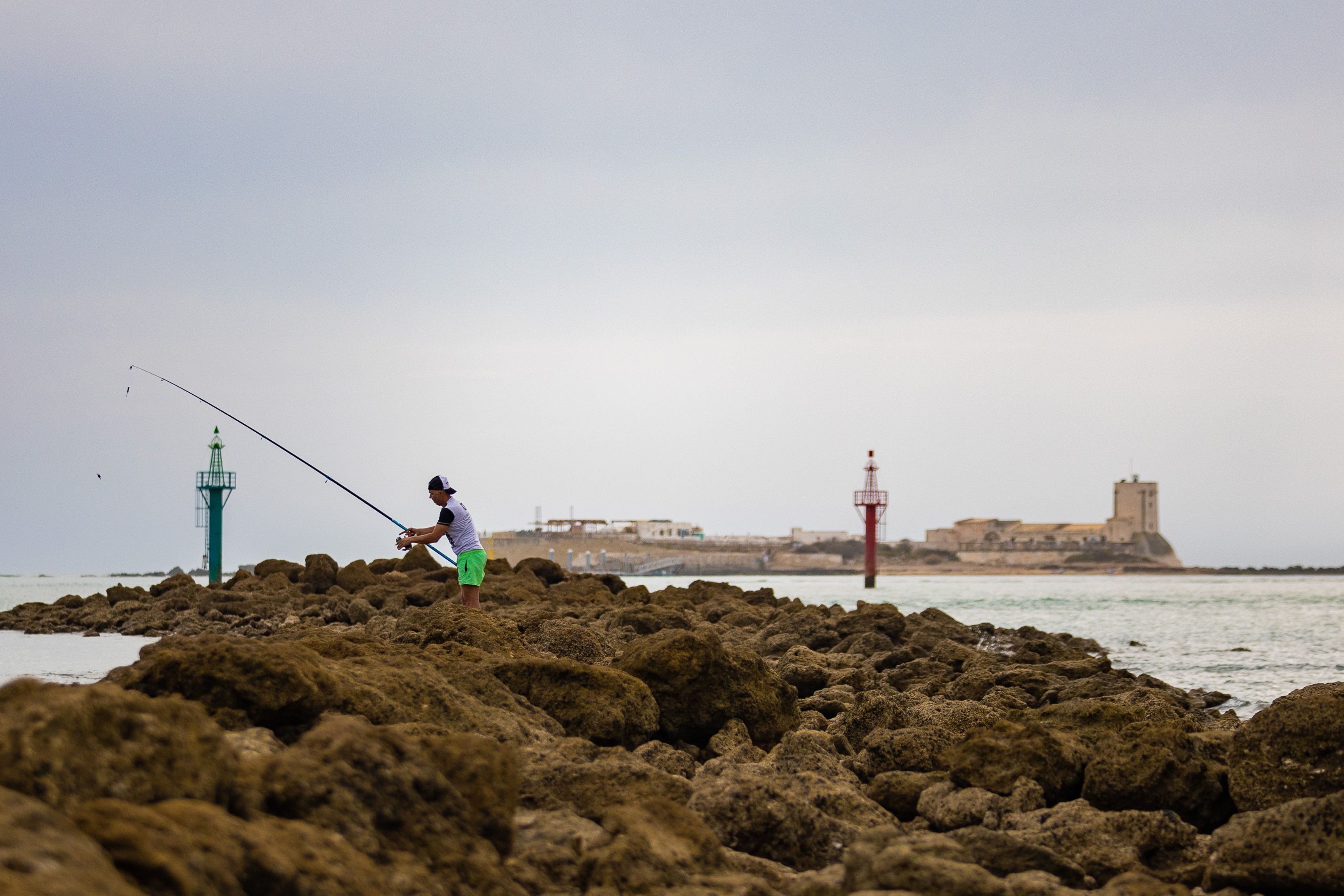 Un joven pesca en Sancti Petri, uno de los rincones más bonitos de Andalucía.
