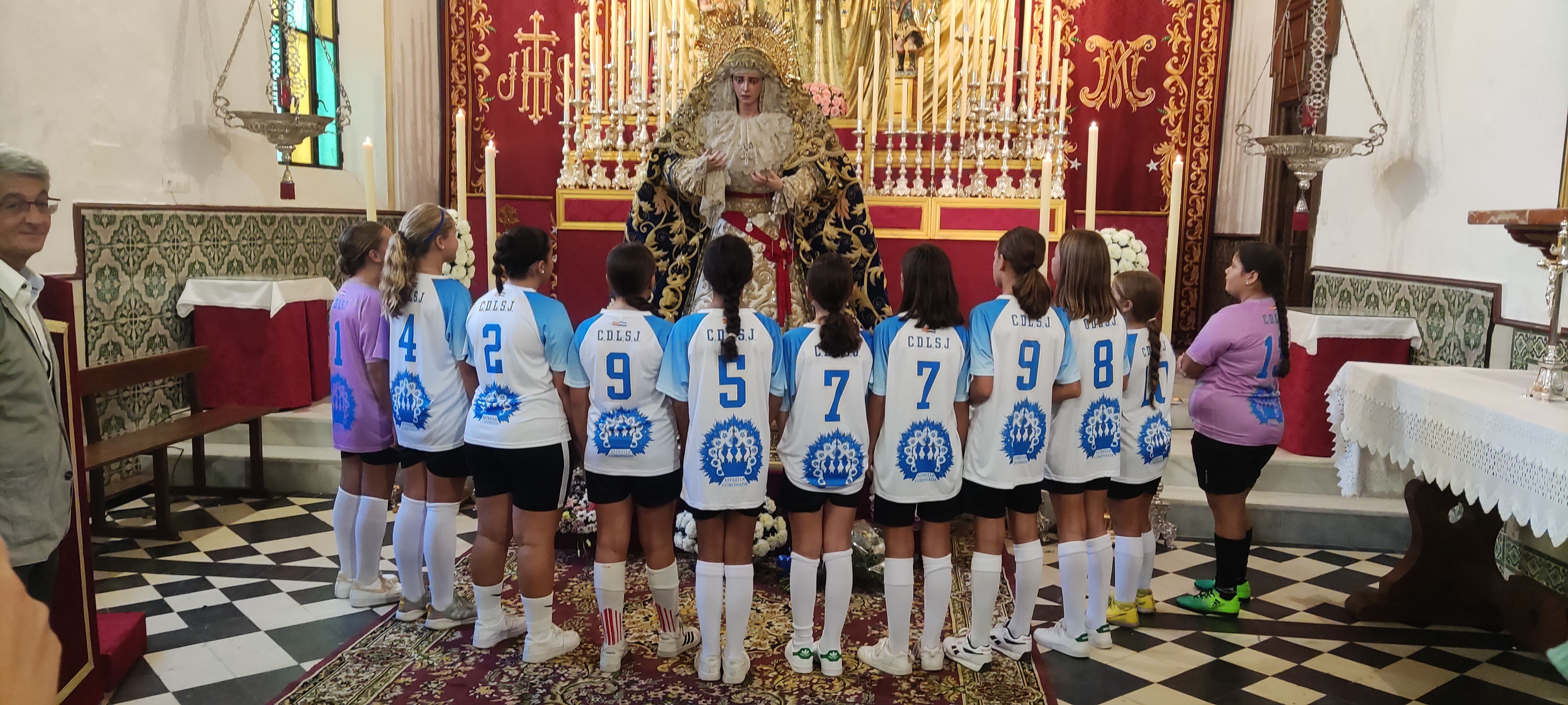 Las jugadoras ante la Virgen de la Estrella, vistiendo la nueva camiseta, en la Escuela de San José.