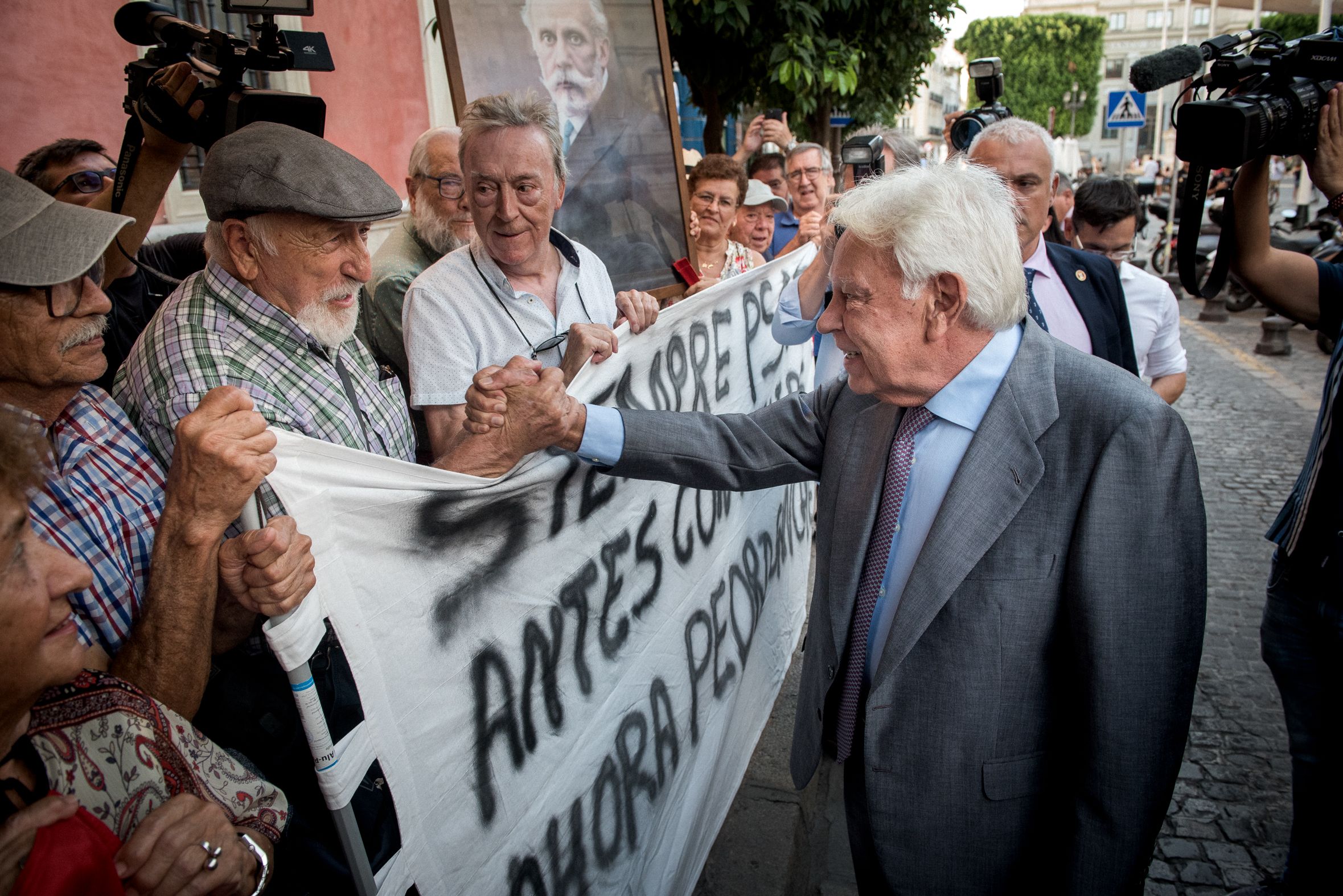 Felipe González saludando a históricos militantes socialistas a su llegada al acto de Sevilla.