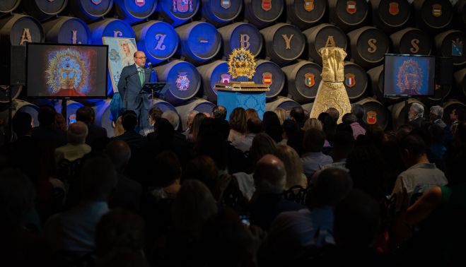 Los asistentes en pie aplaudiendo tras colocarse la corona en el escenario. MANU GARCÍA.