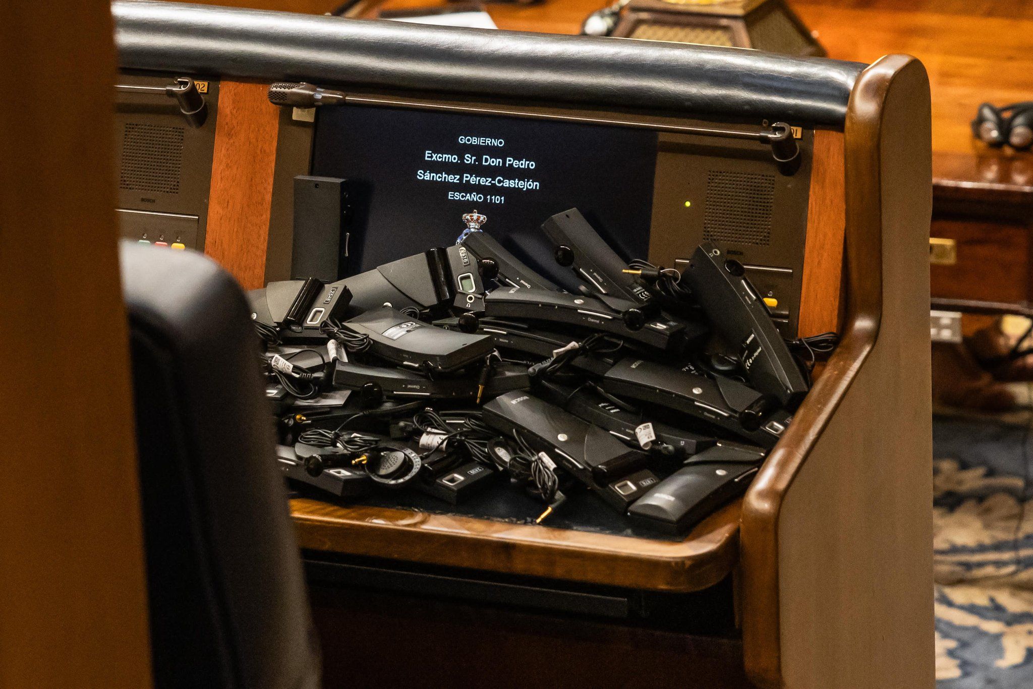 Los pinganillos 'devueltos' por Vox en el escaño de Pedro Sánchez, este martes en el Congreso.