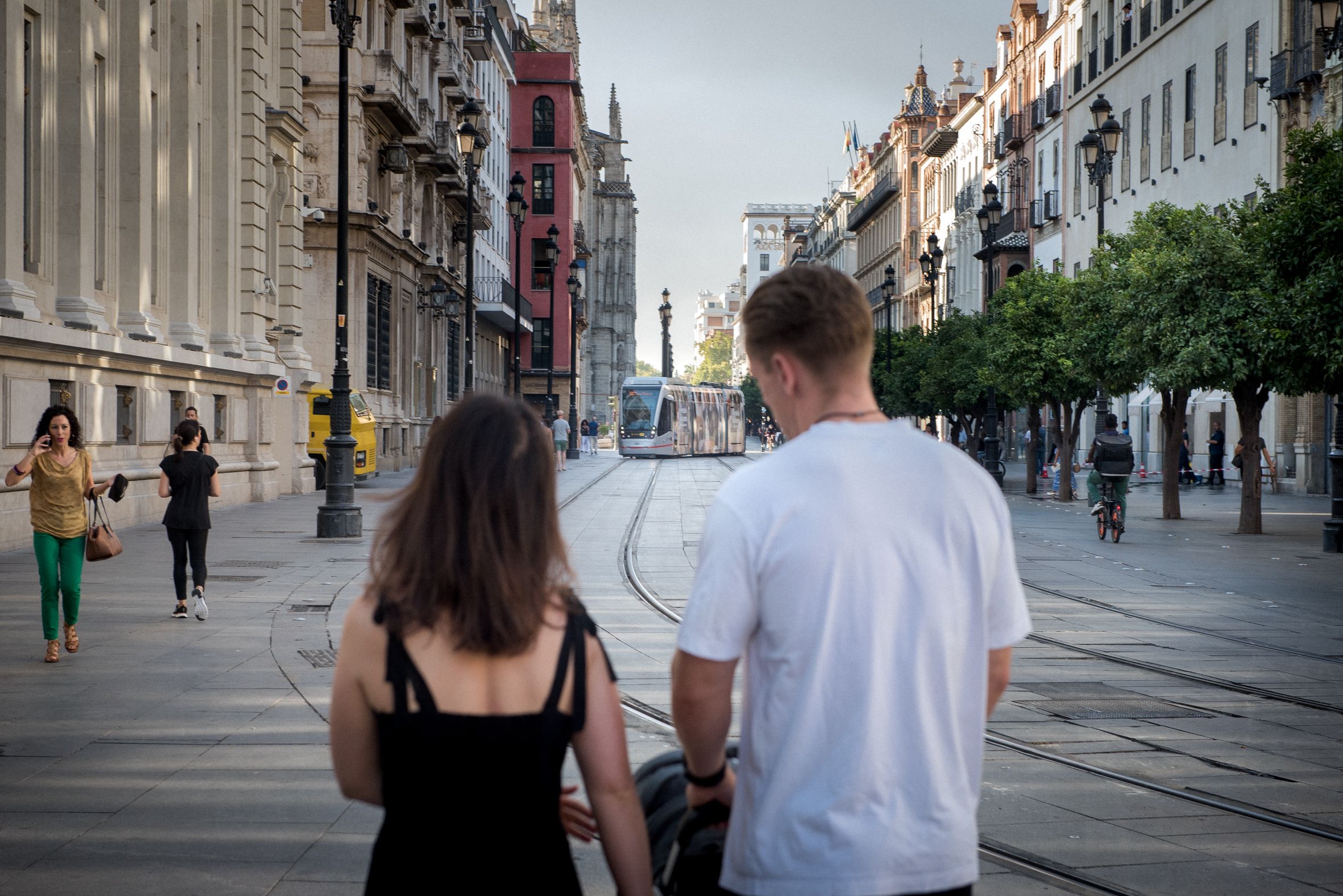 Dos personas pasean por la avenida de la Constitución de Sevilla.