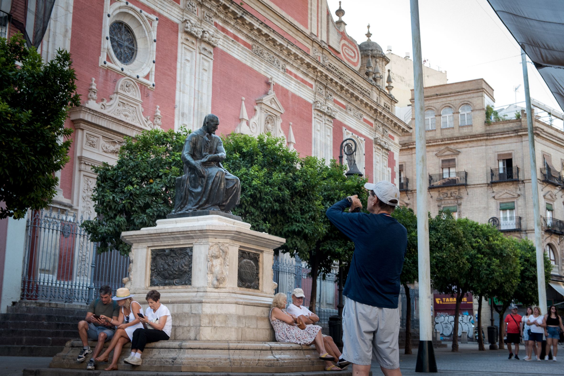 Turistas, haciendo fotos a la estatua de Martínez Montañés en Sevilla.