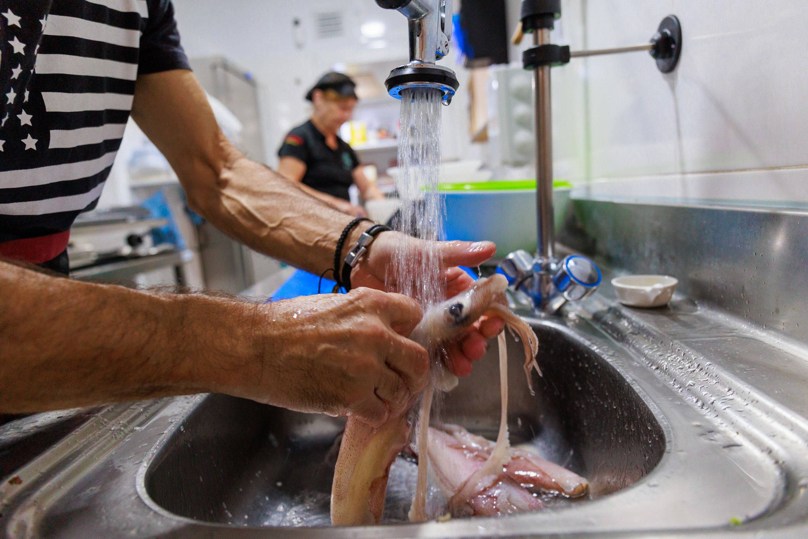 El equipo limpia los calamares en la cocina. 