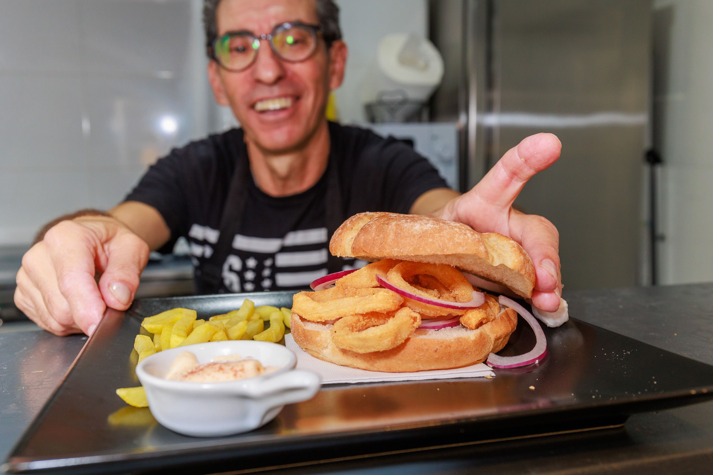 Joaquín Otero, cocinero de la primera calamarería de El Puerto, con un bocadillo de calamares.