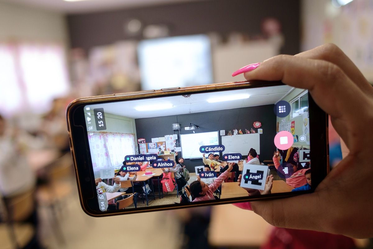 Una docente usa el móvil en un aula en una actividad pedagógica.