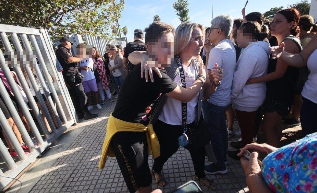 Una madre, abrazada a su hijo, a las puertas del instituto de Jerez donde ha ocurrido el apuñalamiento.
