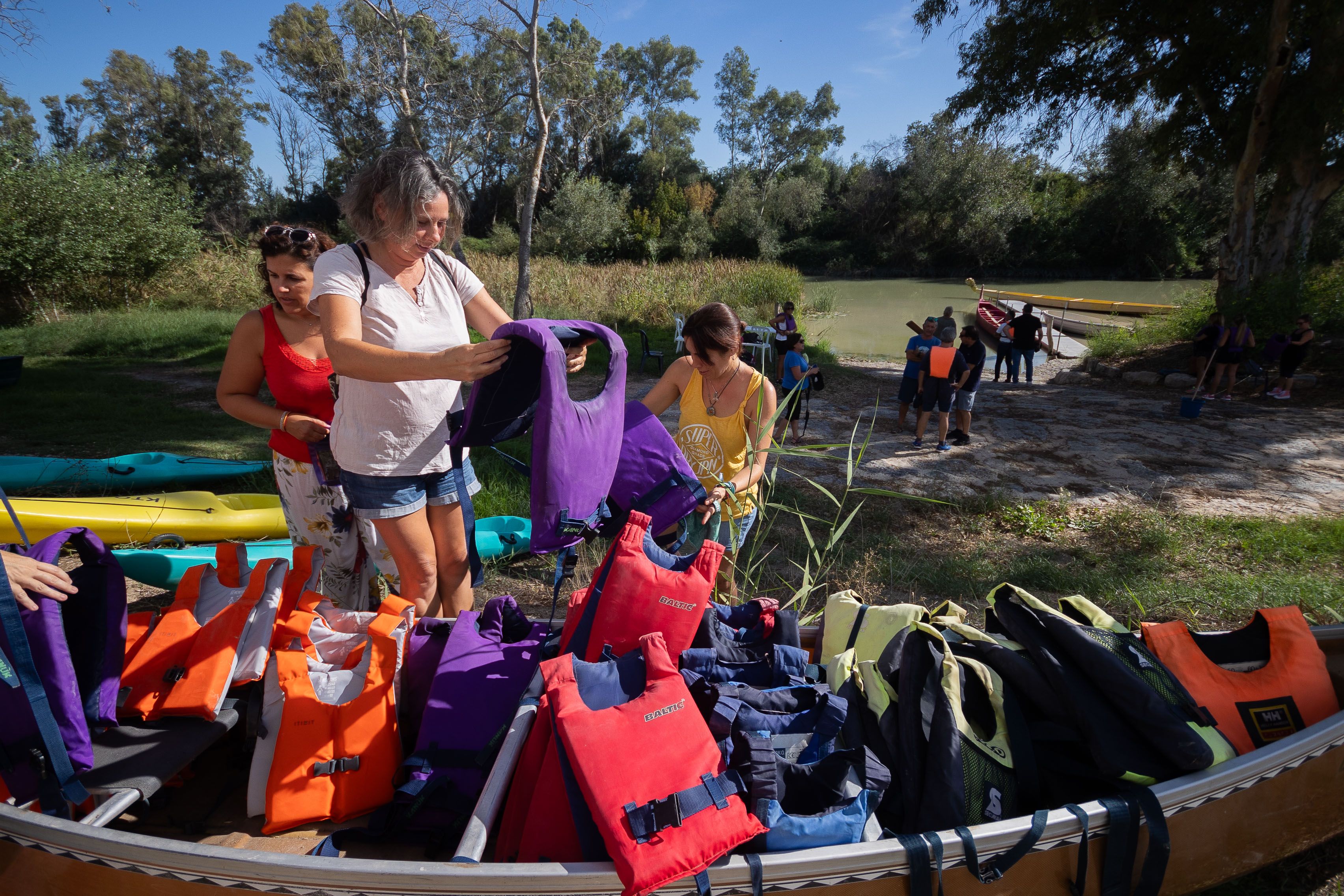 Las personas participantes se colocan los chalecos salvavidas.