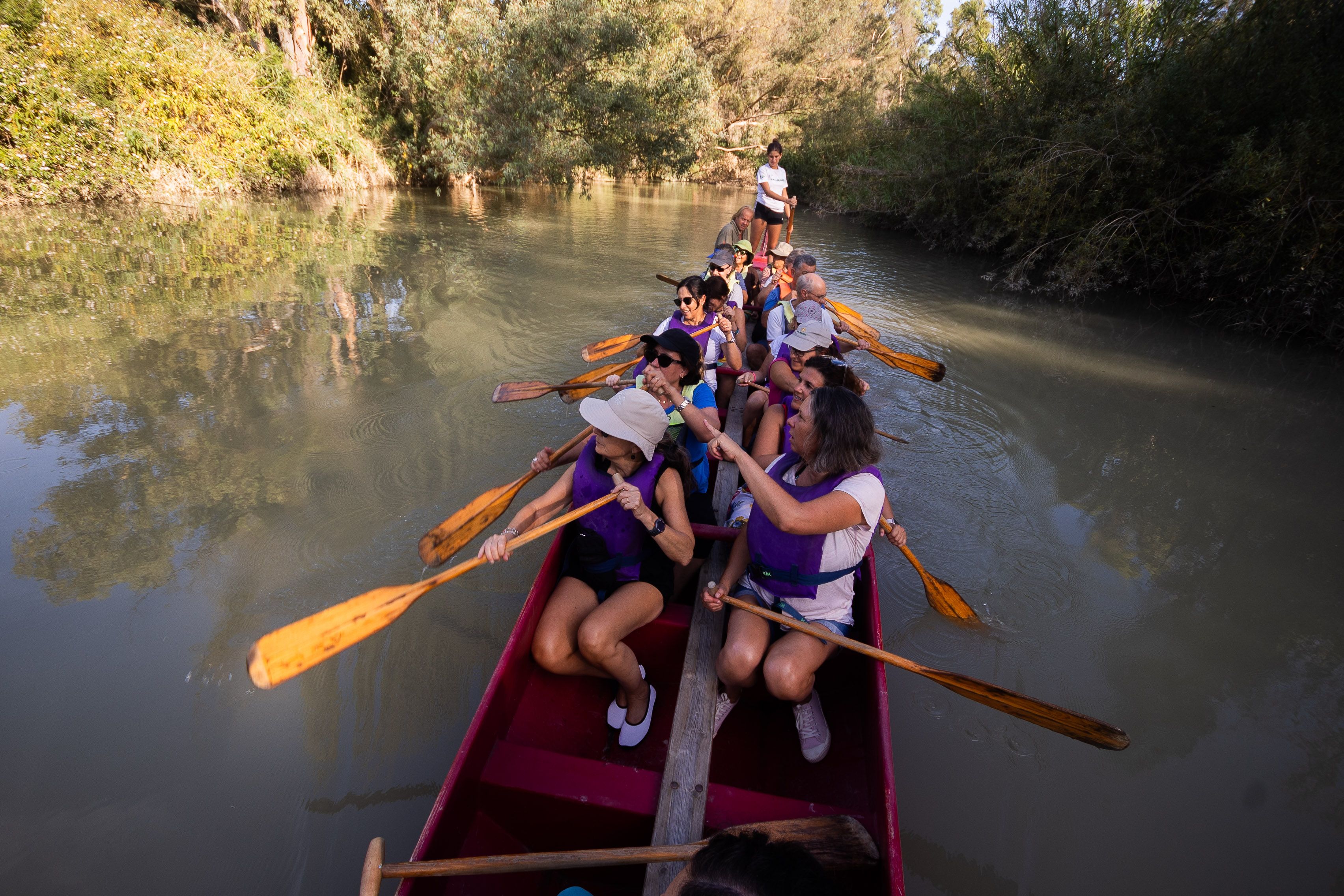 Un grupo de personas disfrutan de una travesía en barco dragón por el río Guadalete. 
