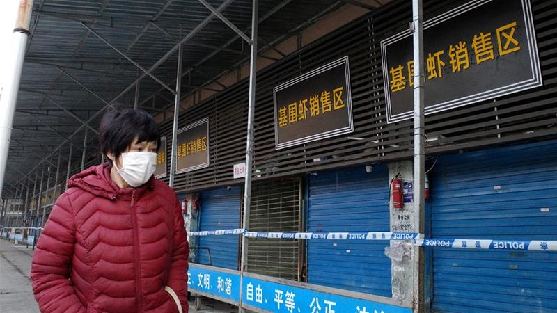 Una ciudadana china pasa por el mercado de Wuhan, durante la pandemia.