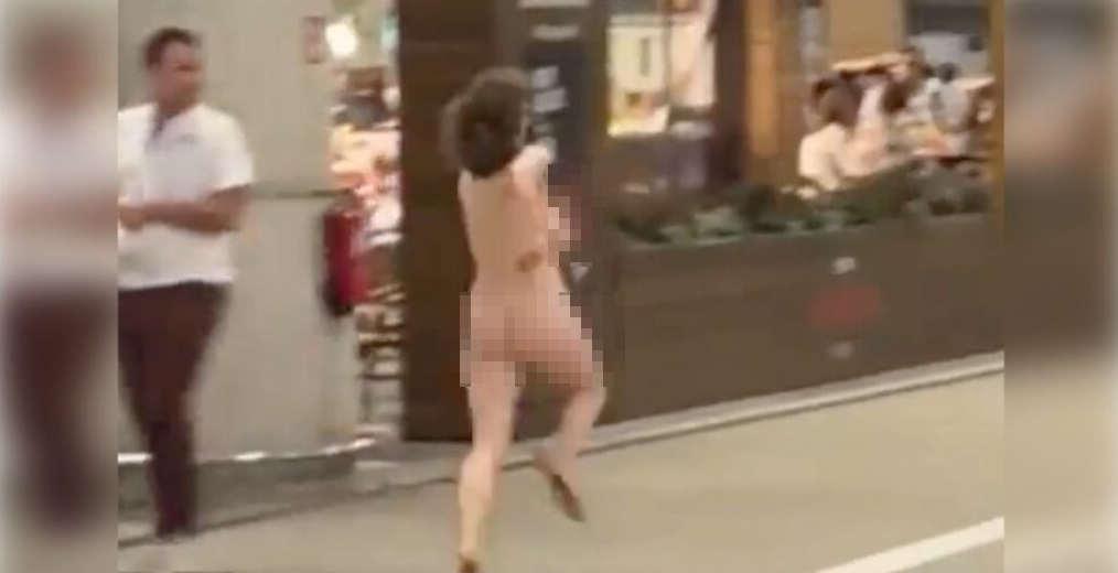 Una mujer desnuda corre tras escapar de dos agentes de la Policía.