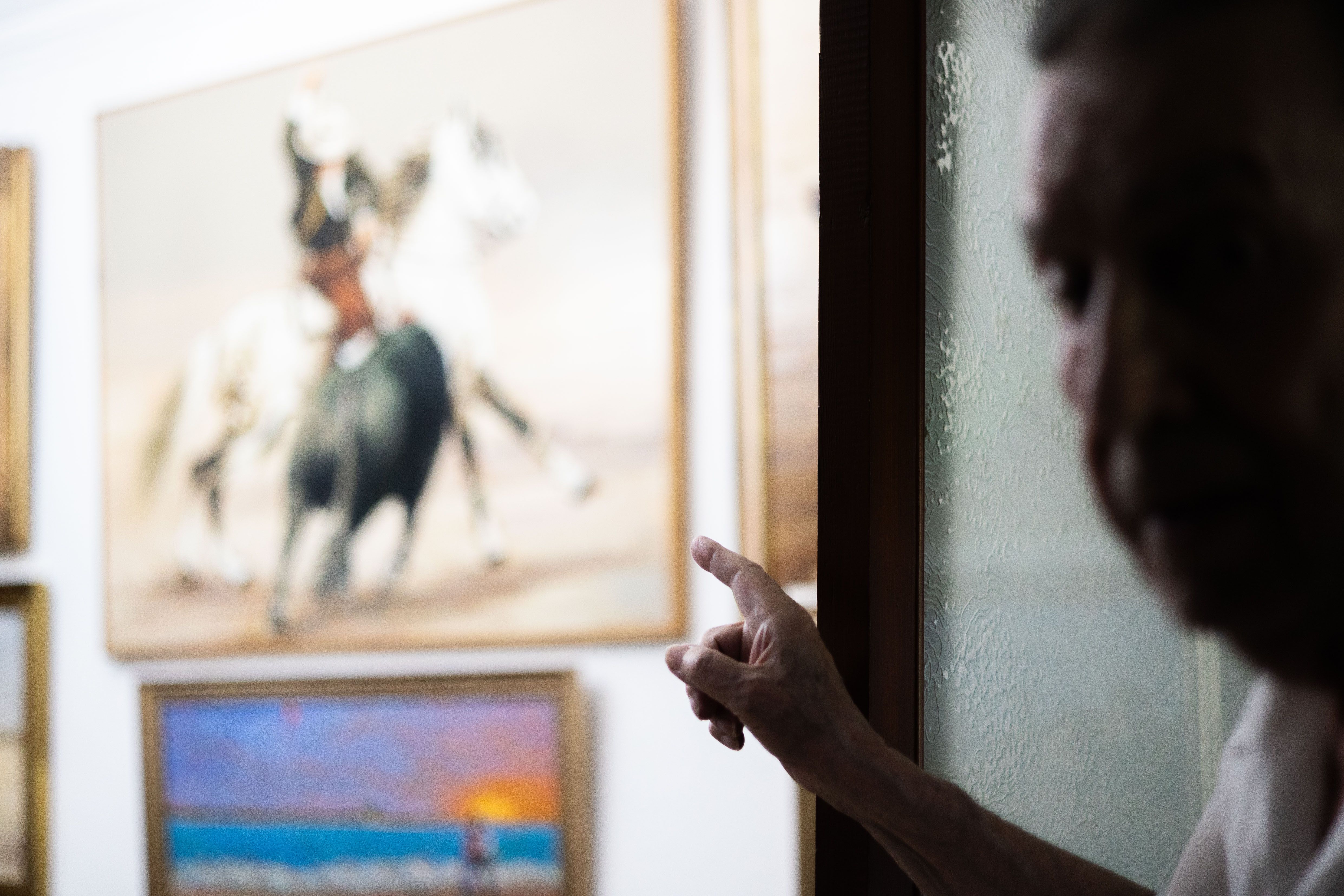 Indicando un cuadro de rejoneo que cuelga en lugar privilegio en la entrada a su piso. MANU GARCÍA