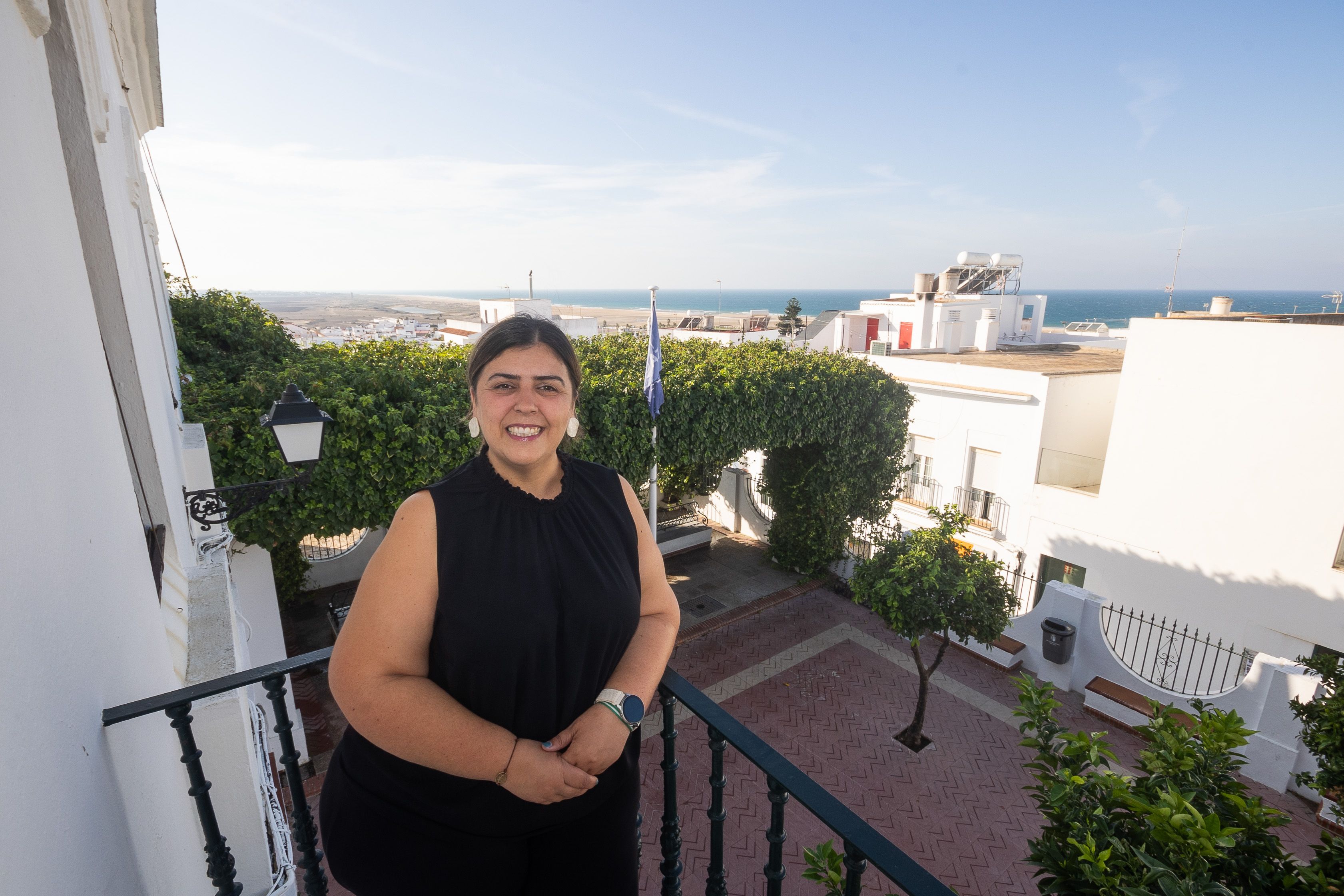 Inmaculada Sánchez Zara, alcaldesa de Conil, en el balcón del Ayuntamiento con el horizonte marino al fondo.