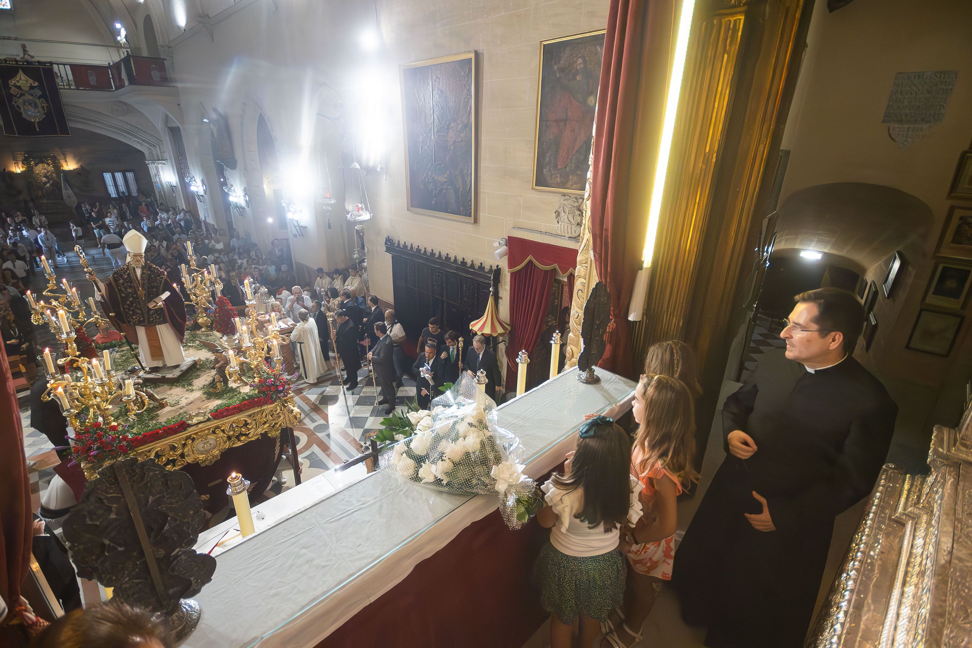 el párroco en el camarín de La Merced tras la ofrenda floral y mirando al paso del Patrón.        MANU GARCÍA 