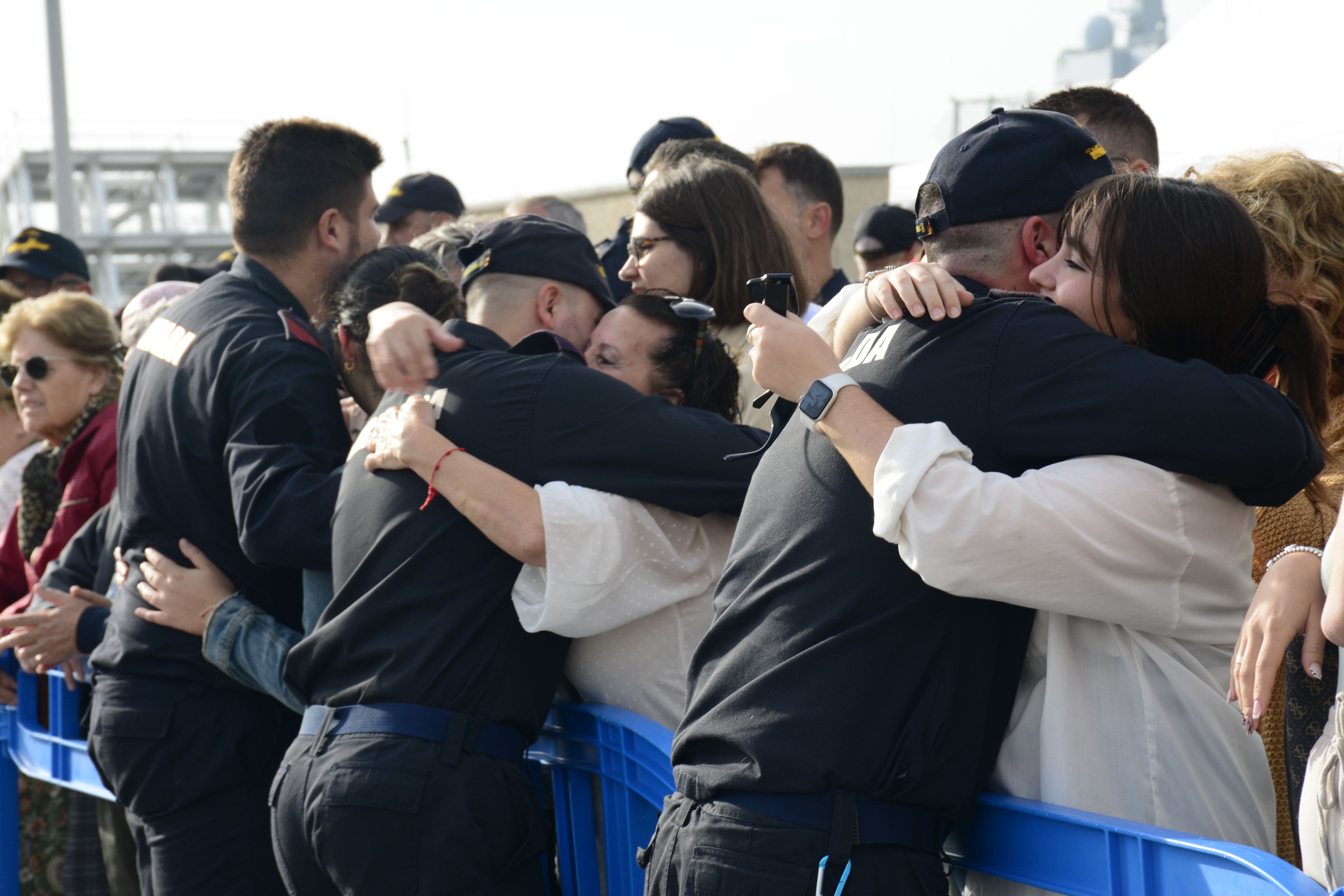 Los familiares abrazan a los militares que han zarpado.