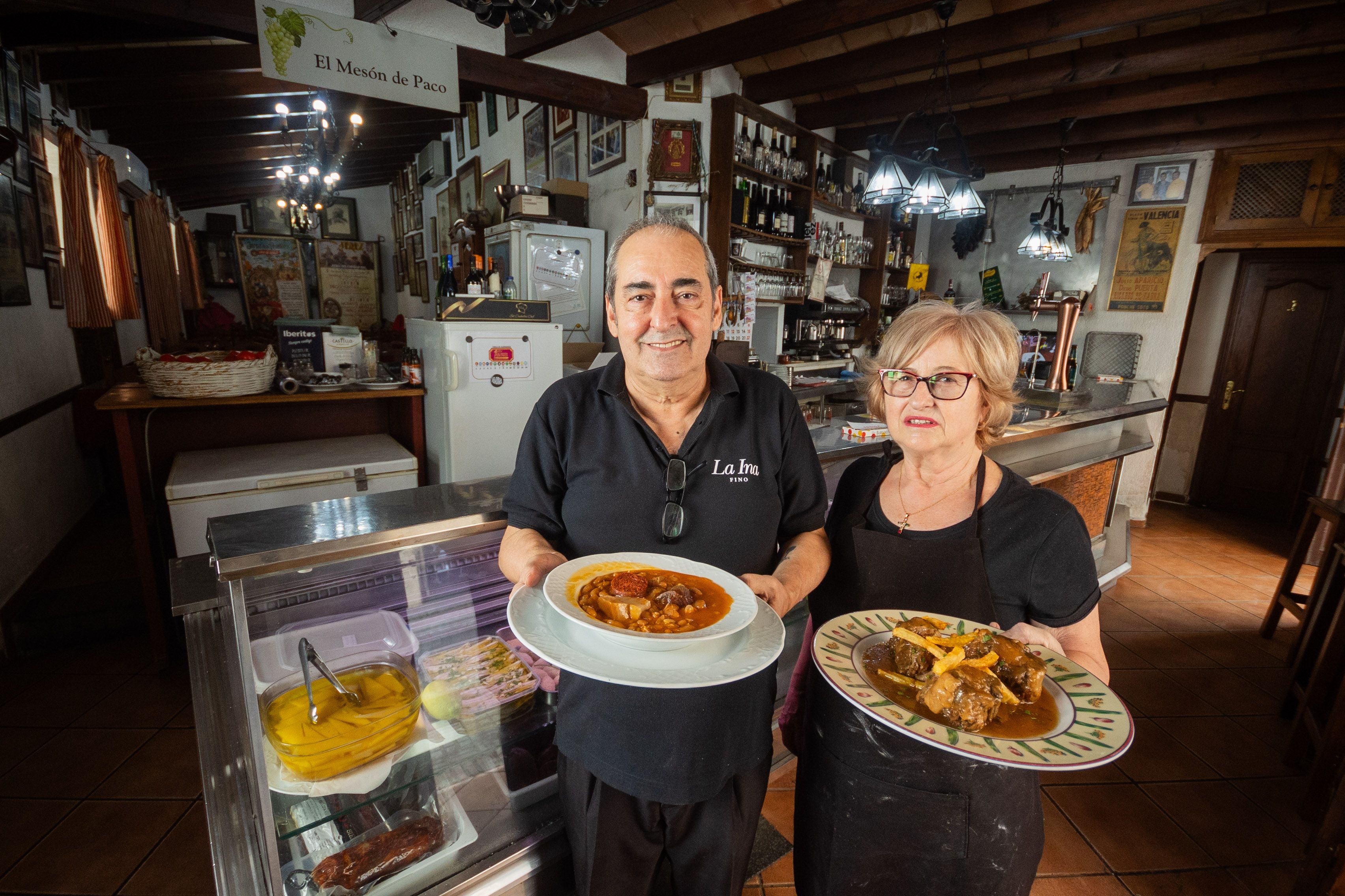Paco Braza y su esposa en su mesón con los platos del día.