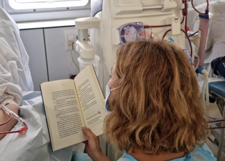 Voluntarios leen novelas a pacientes del Hospital de Jerez. En la imagen, una mujer leyendo a un paciente de diálisis. 