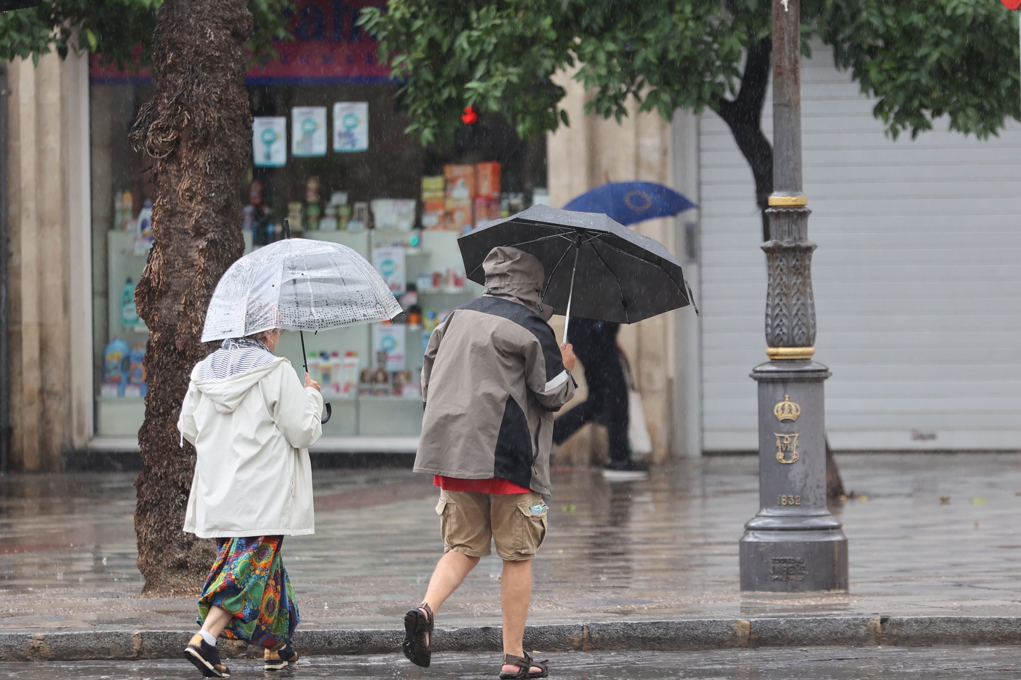 Nuevas borrascas barren la península con especial incidencia el miércoles en Andalucía. En la imagen, dos viandantes protegiéndose de la lluvia.