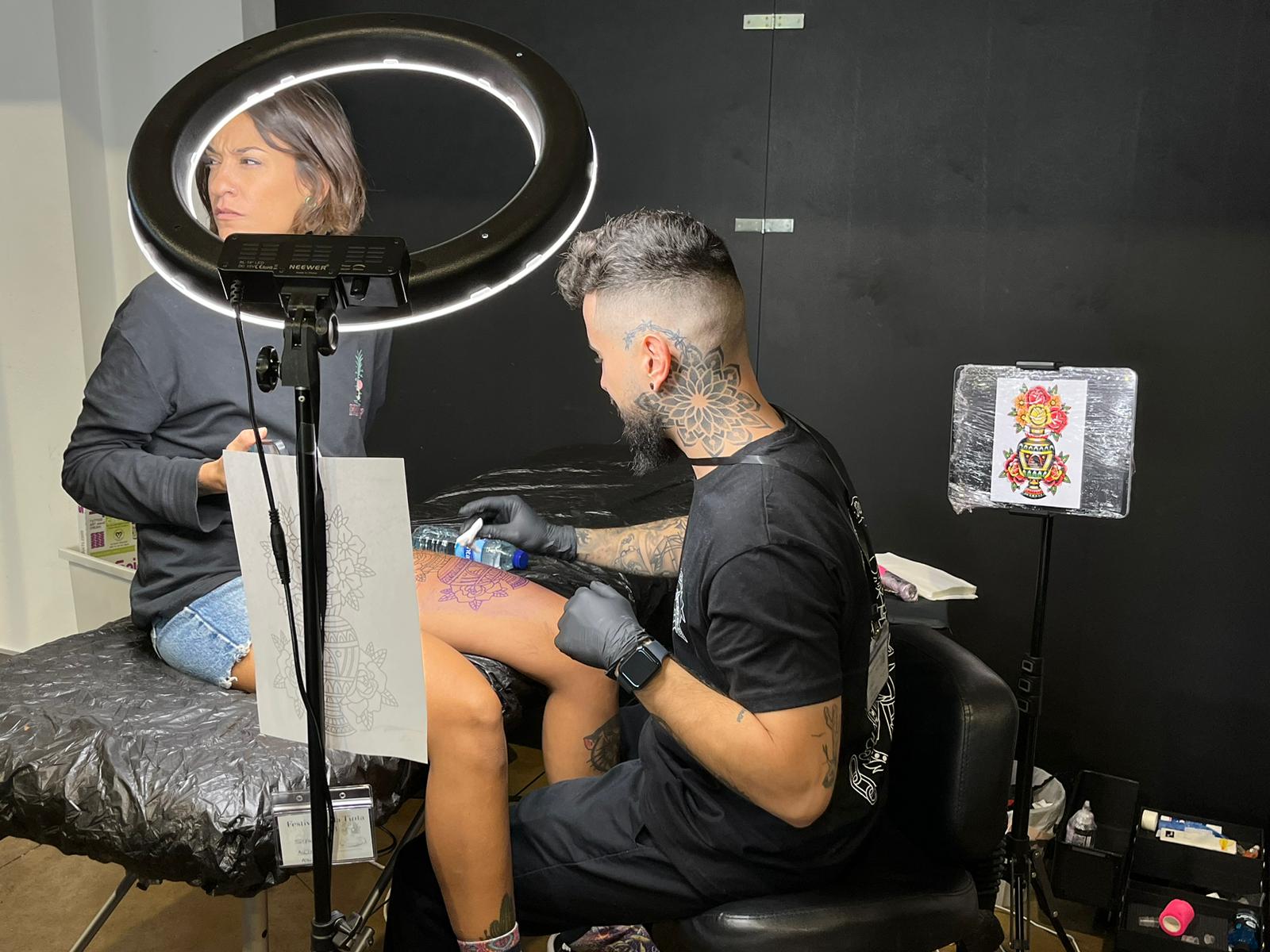 Uno de los stands del Festival de la Tinta, con una chica en pleno tatuaje.