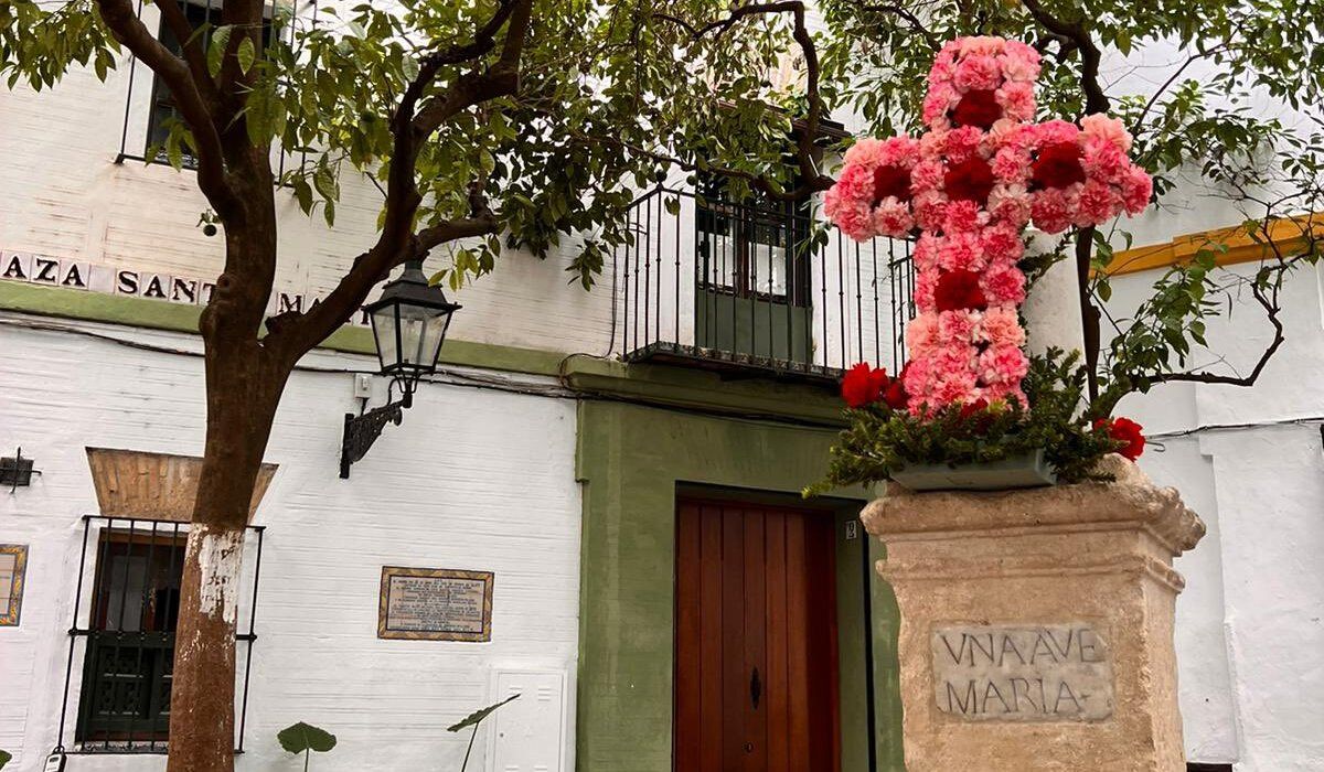 La cruz de flores en la plaza de Santa Marta, en el centro de Sevilla, este lunes.
