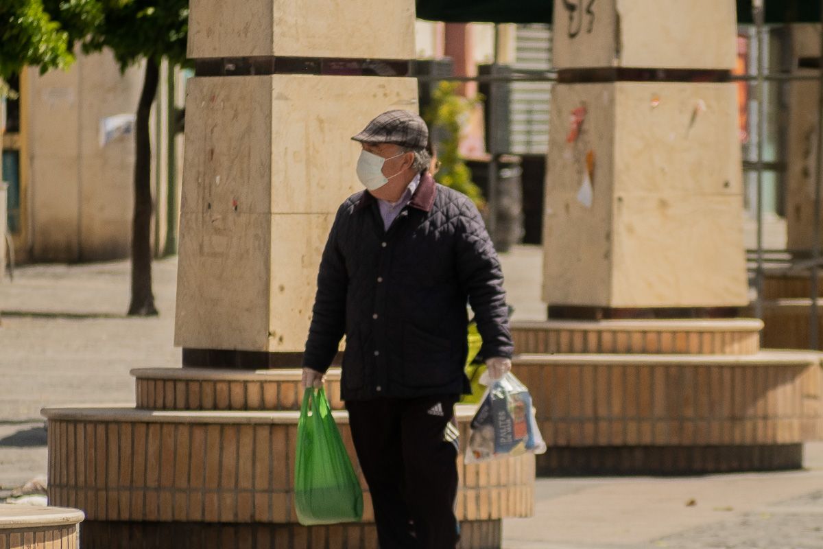 Imagen de archivo de una persona con bolsas de la compra.