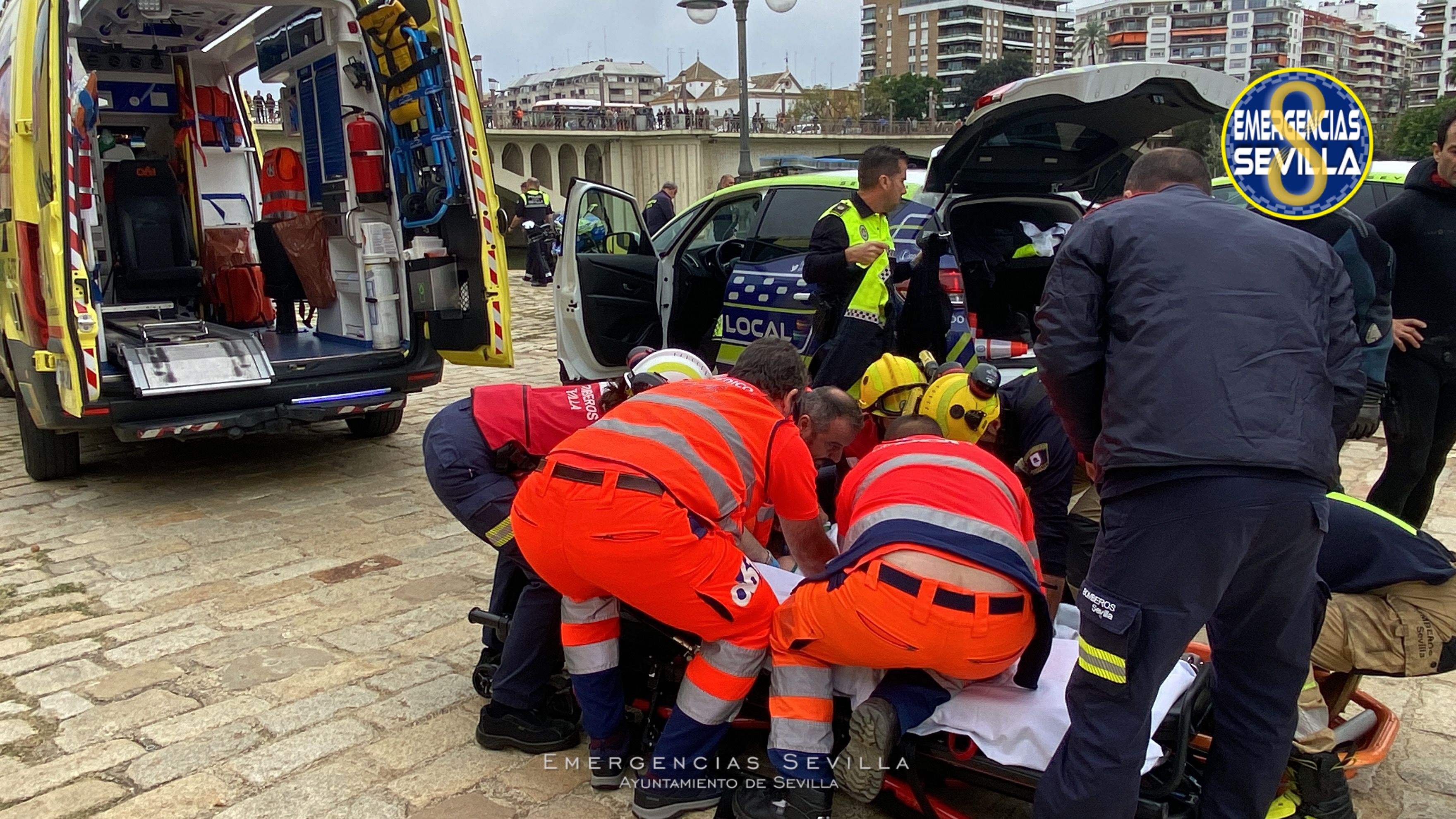 El 061 atiende a la mujer tras el rescate del río.