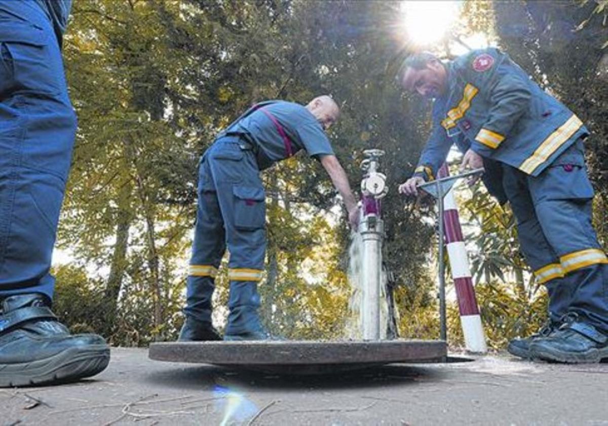 Una boca de riego siendo utilizada por bomberos. 
