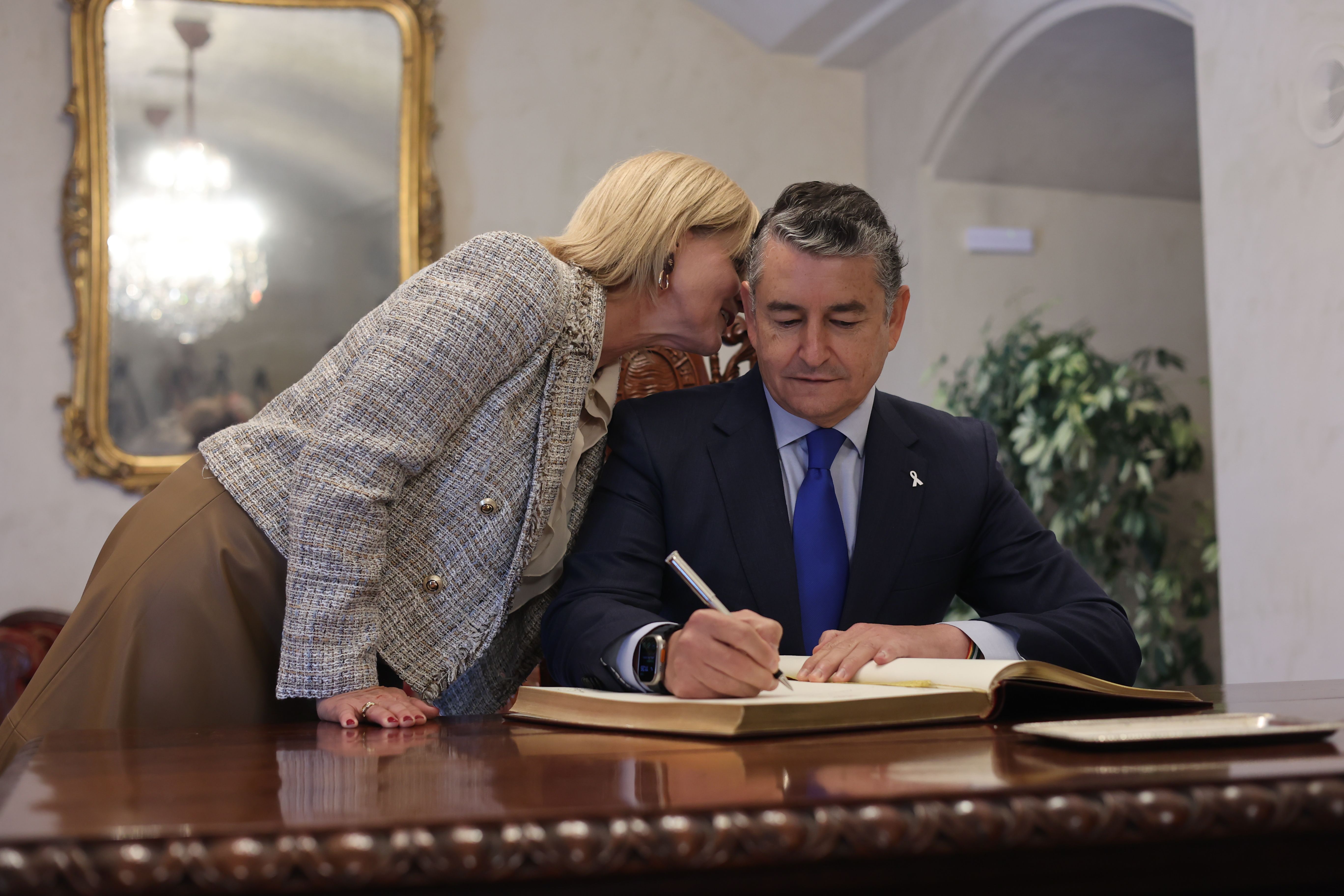 María José García-Pelayo, alcaldesa de Jerez, susurra algo al oído de Antonio Sanz, mientras este firma en el libro de honor del Ayuntamiento, este viernes.