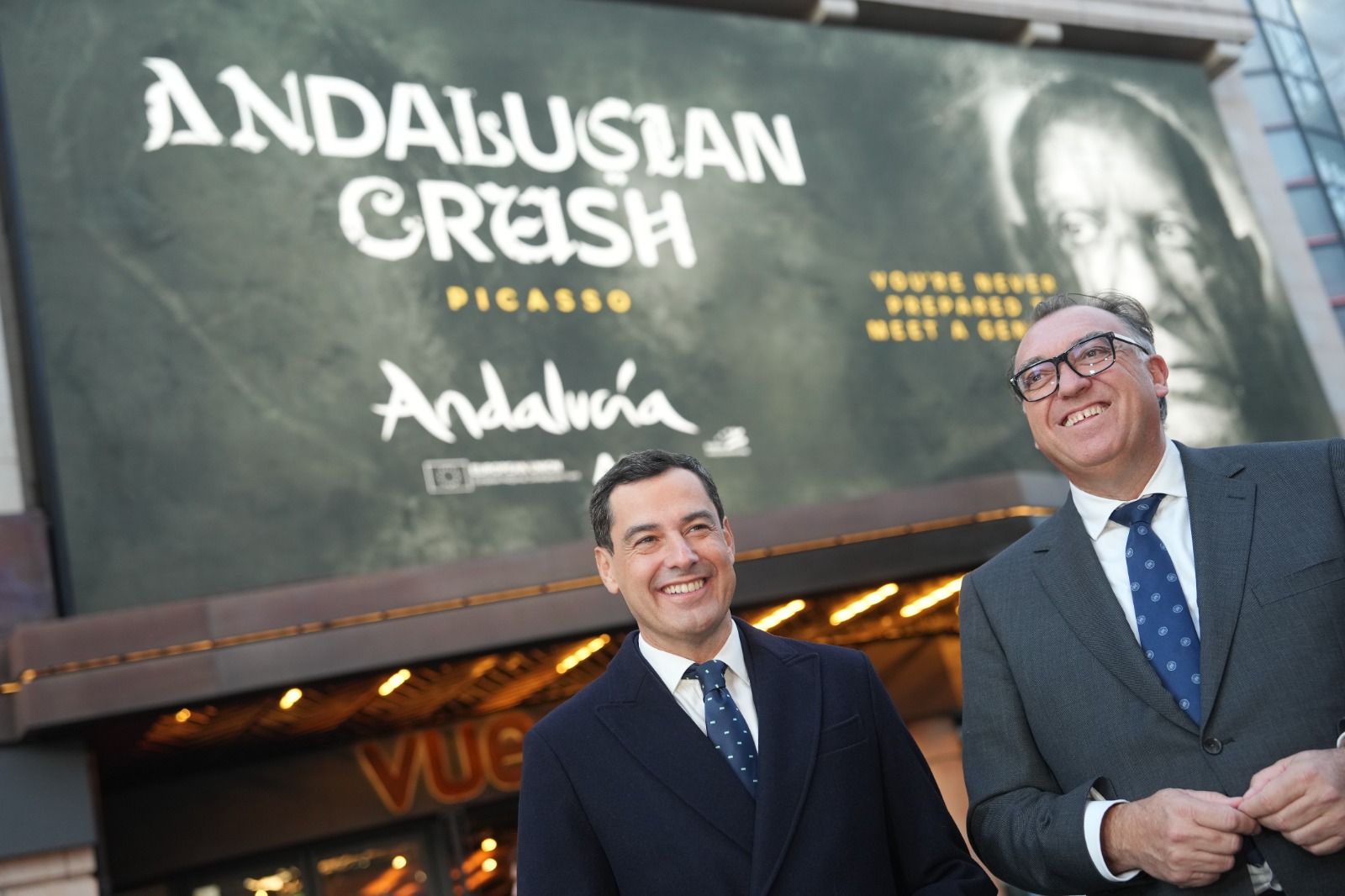 Juanma Moreno y Arturo Bernal con una imagen de la campaña 'Andalusian Crush' en el centro de Londres.