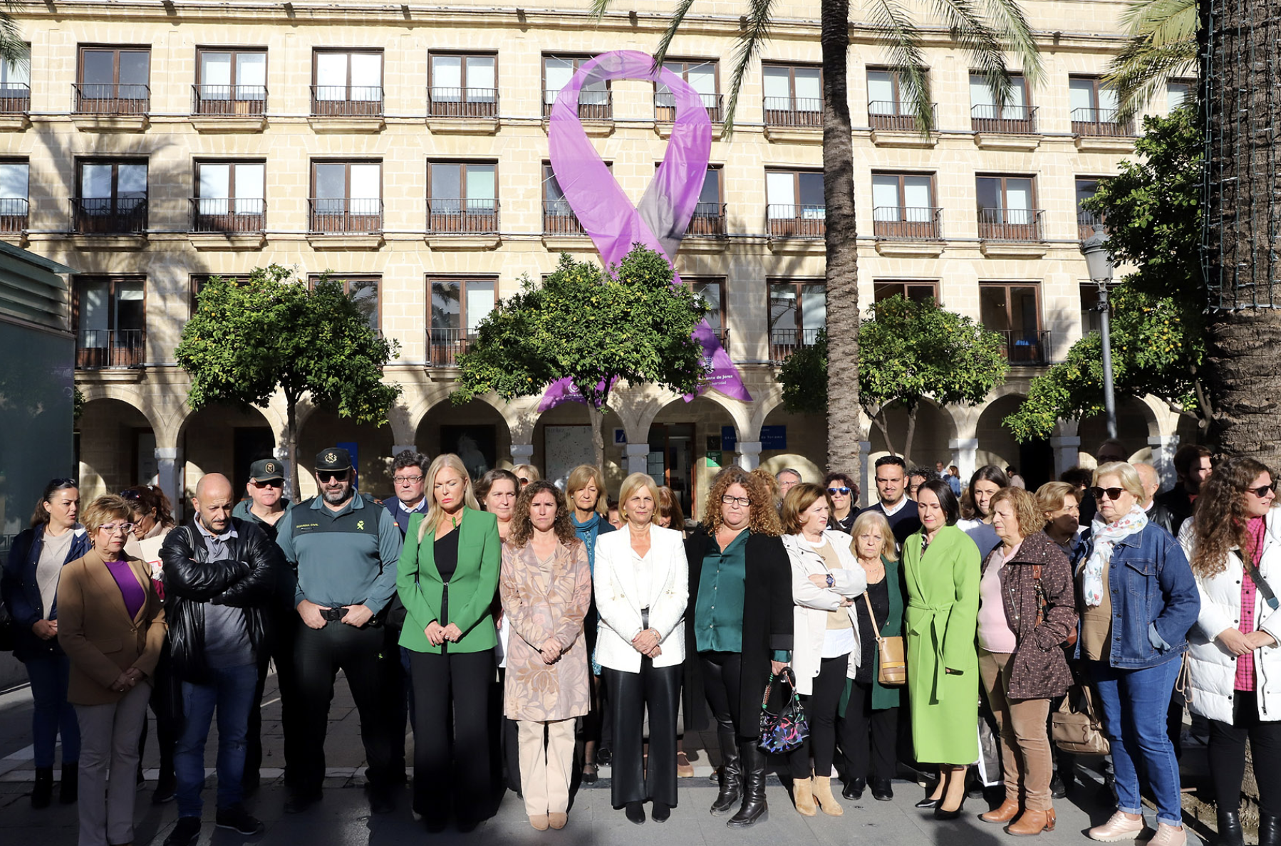 Acto de colocación del lazo morado en la fachada del edificio Los Arcos en la plaza del Arenal de Jerez. Acto de colocación del lazo morado en la fachada del edificio Los Arcos en la plaza del Arenal de Jerez.