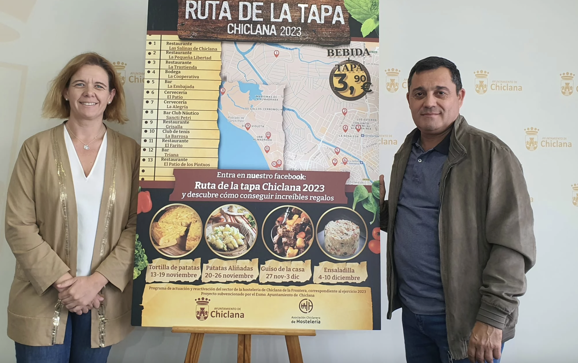 13 bares y restaurantes participan en la 'Ruta de la Tapa Chiclana 2023'. La delegada y el presidente de los hosteleros junto al cartel de la ruta.