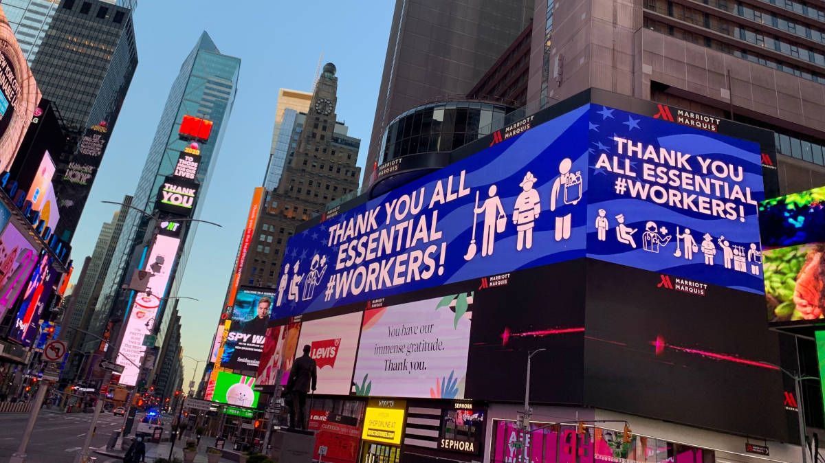 La siempre bulliciosa Times Square de Nueva York, semivacía y con un homenaje a los sanitarios en uno de sus luminosos. 