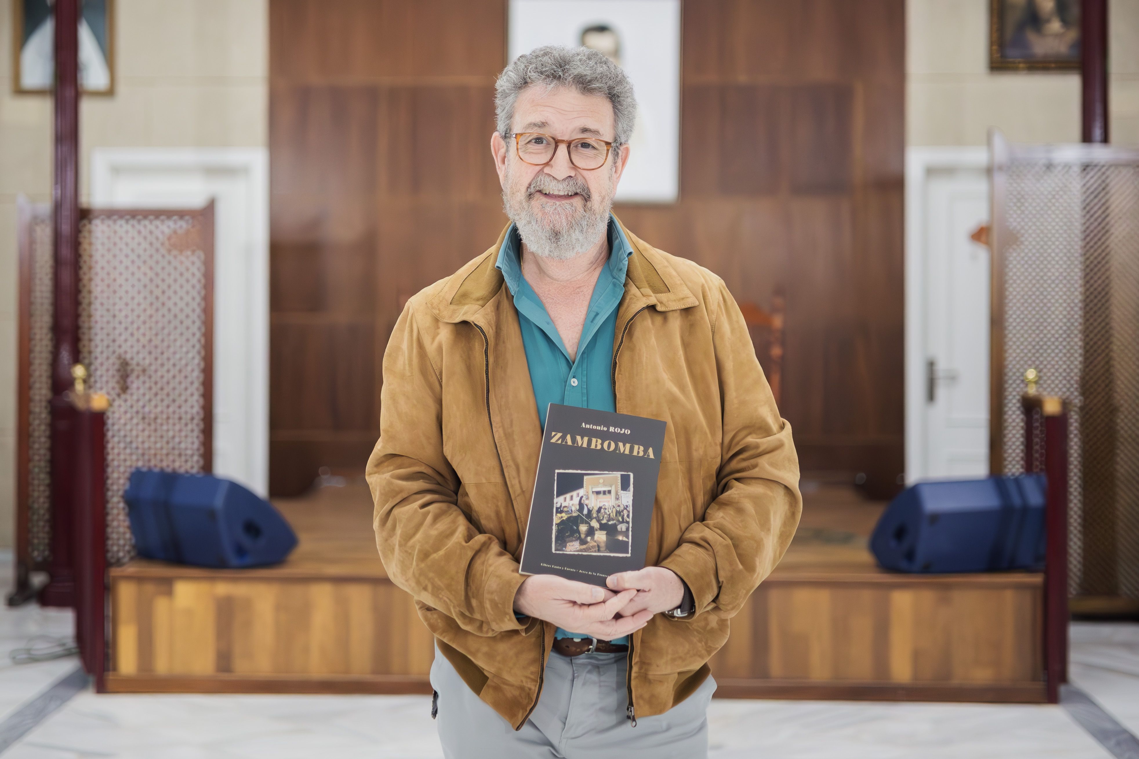 El autor de 'Zambomba' posa con su novela tras la entrevista. 