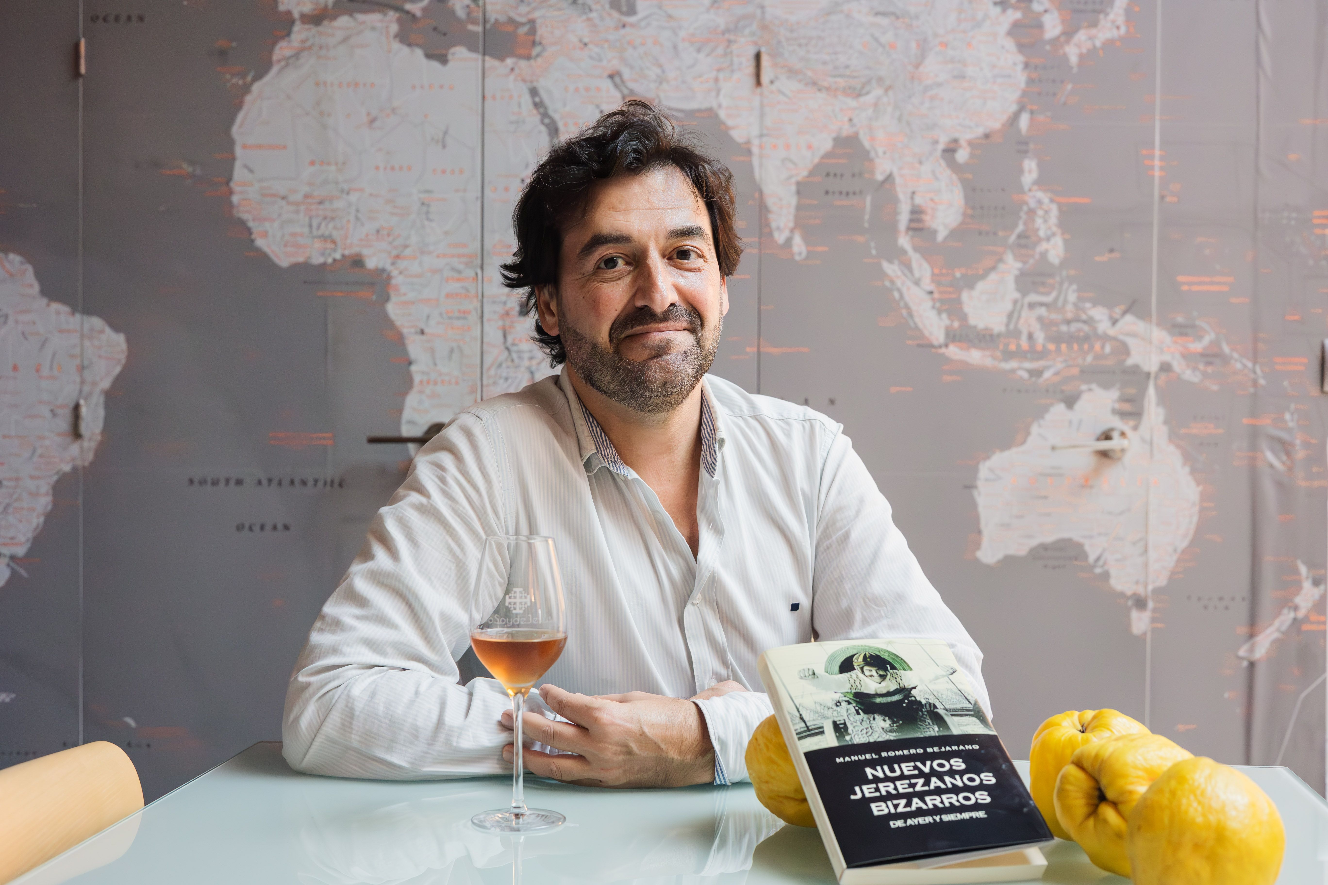 Manuel Romero, gran viajero, posa con un mapa mundi que tiene en su casa.