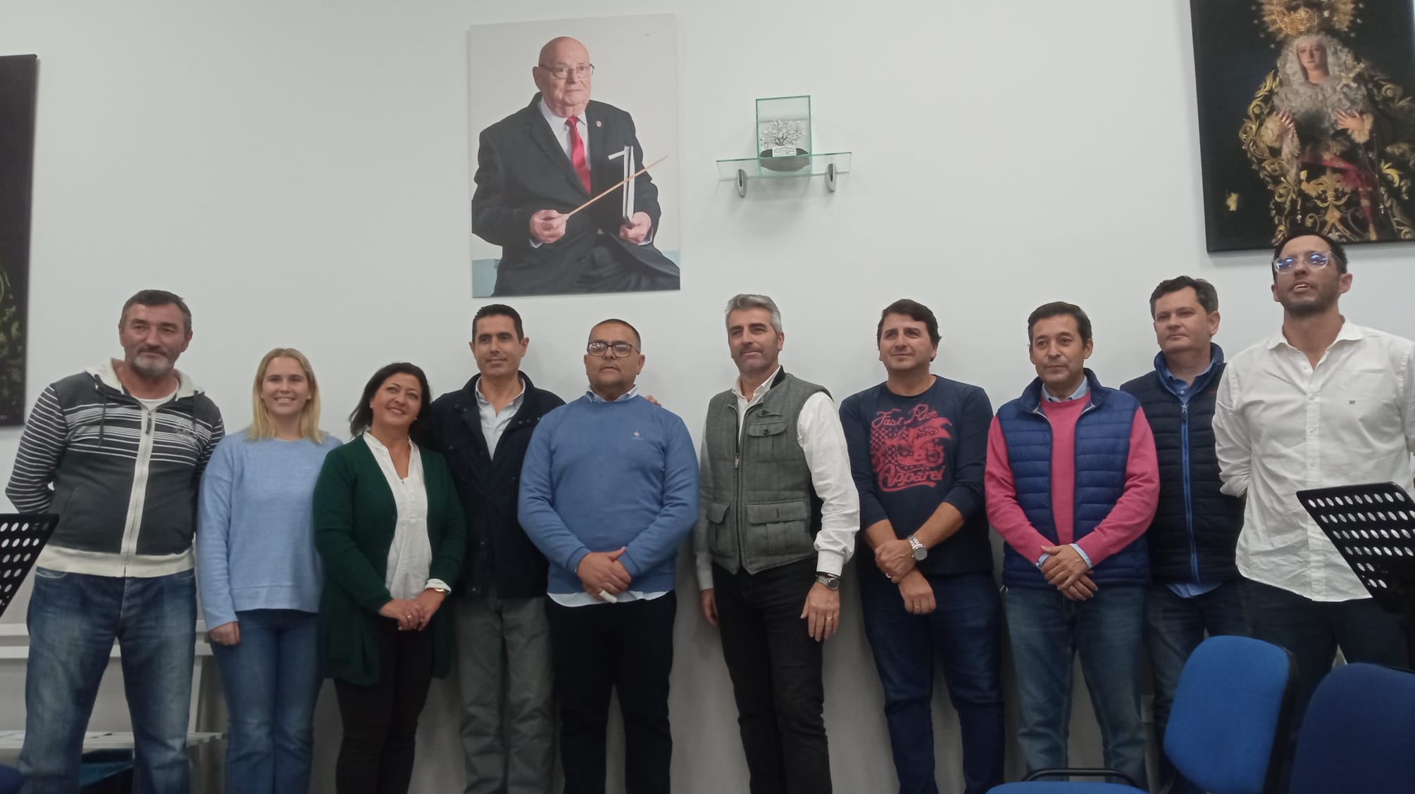 El hermano mayor junto al director de la banda y miembros de la misma tras la firma del contrato. 